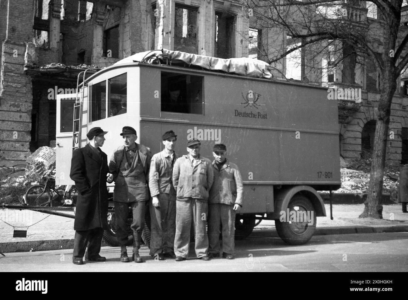 Les employés de Deutsche Post, en face d'une camionnette dans une rue détruite pendant la Seconde Guerre mondiale. Banque D'Images