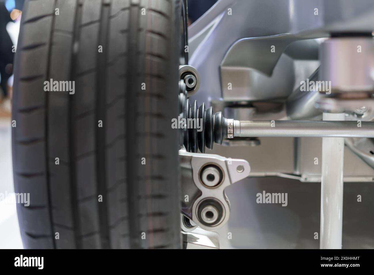 Explorez l'avant-garde de l'ingénierie automobile avec une vue détaillée de la structure de suspension et du nouveau pneu sur l'essieu avant d'une voiture électrique. Th Banque D'Images