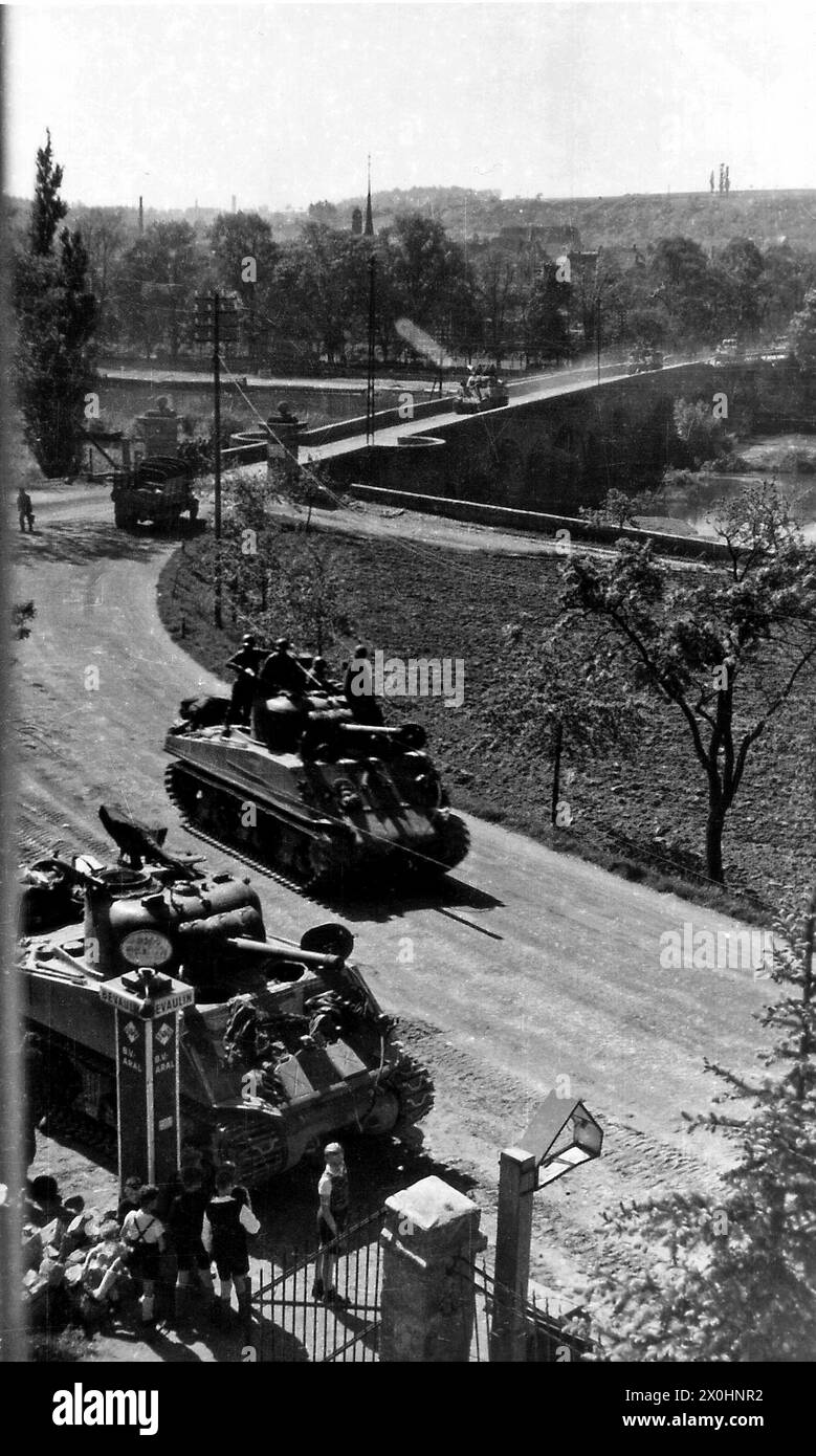 Un groupe d'enfants regarde deux chars de l'armée américaine devant une station-service ARAL à Ochsenfurt. [traduction automatique] Banque D'Images