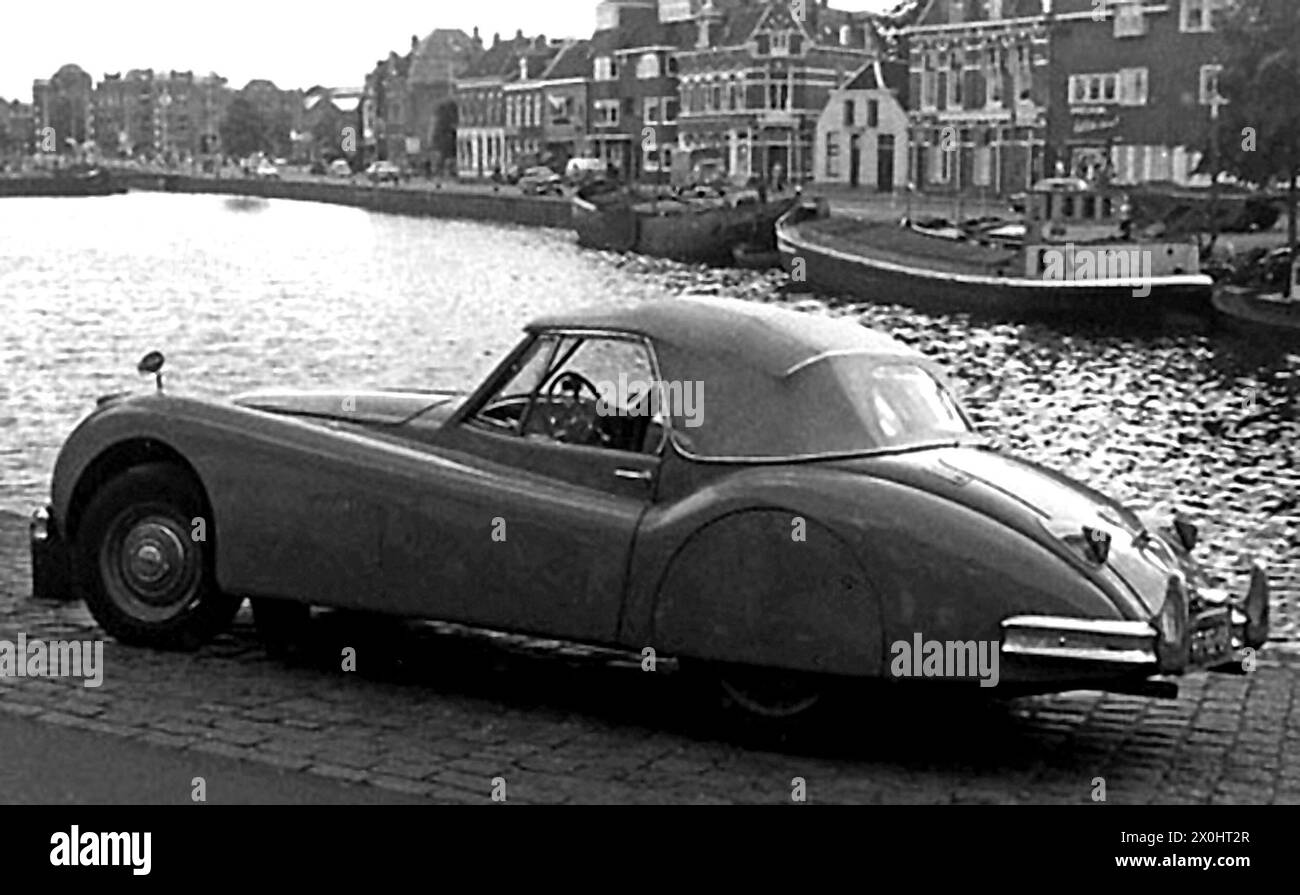 Une Jaguar XK 140 se trouve sur la rive d'un bassin portuaire (emplacement inconnu). [traduction automatique] Banque D'Images