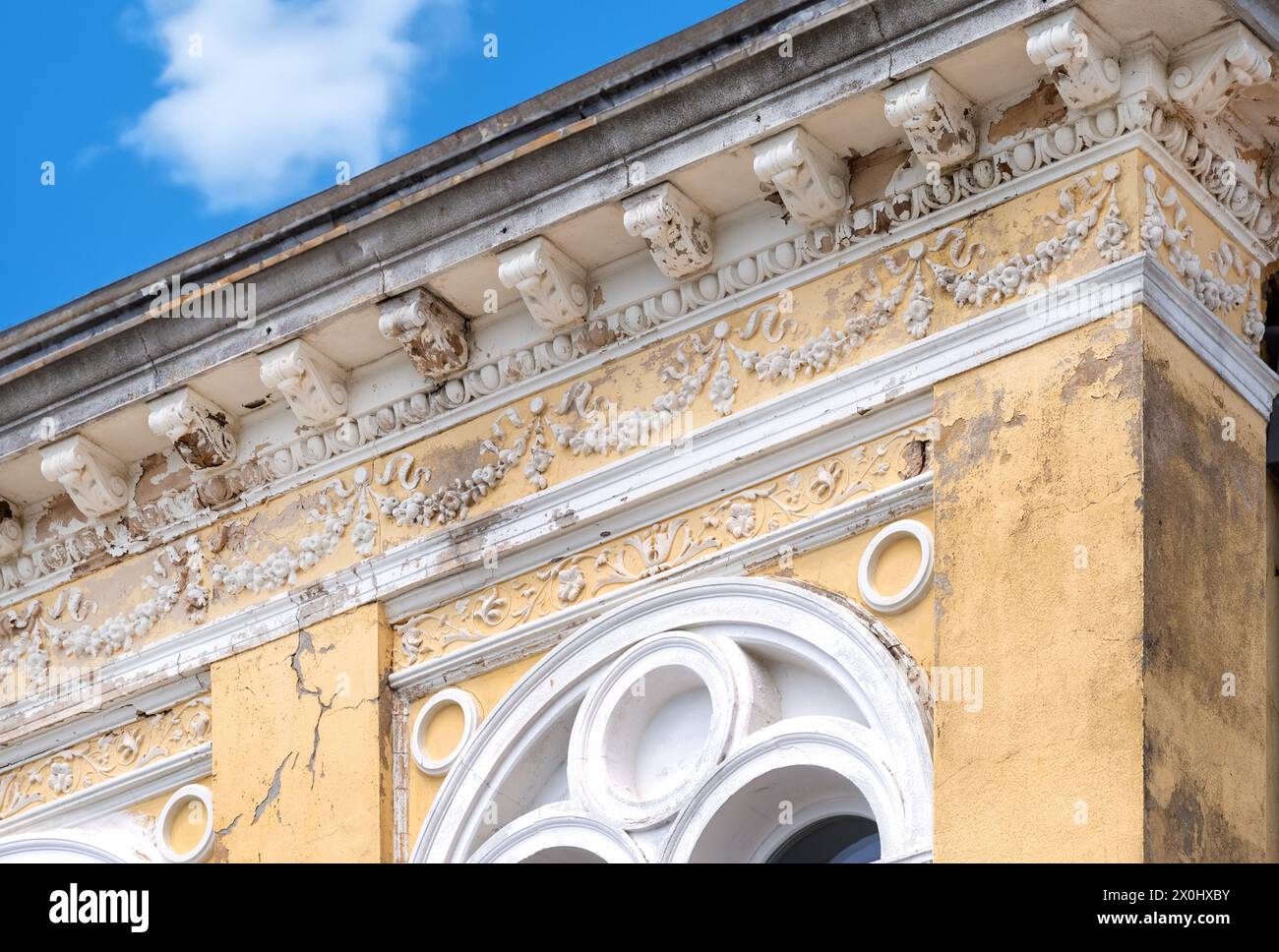 Façade de maison avec stuc fissuré. Restaurer la façade du bâtiment historique. Revêtement en plâtre et réparation de fissures Banque D'Images