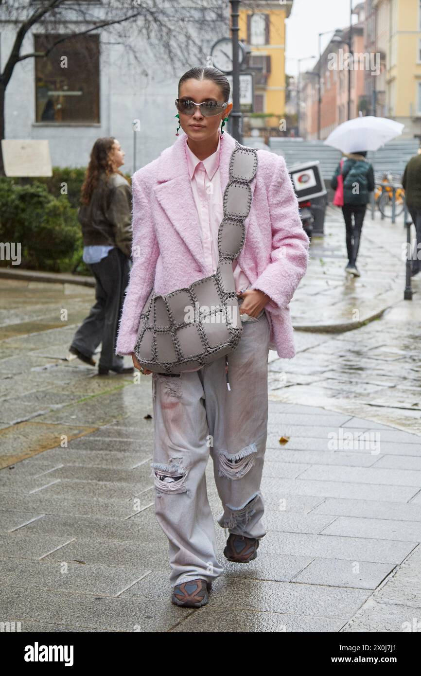 MILAN, ITALIE - 23 FÉVRIER 2024 : veste rose femme, chemise et pantalon en denim déchiré avant le défilé Blumarine, style Street week Milan Banque D'Images