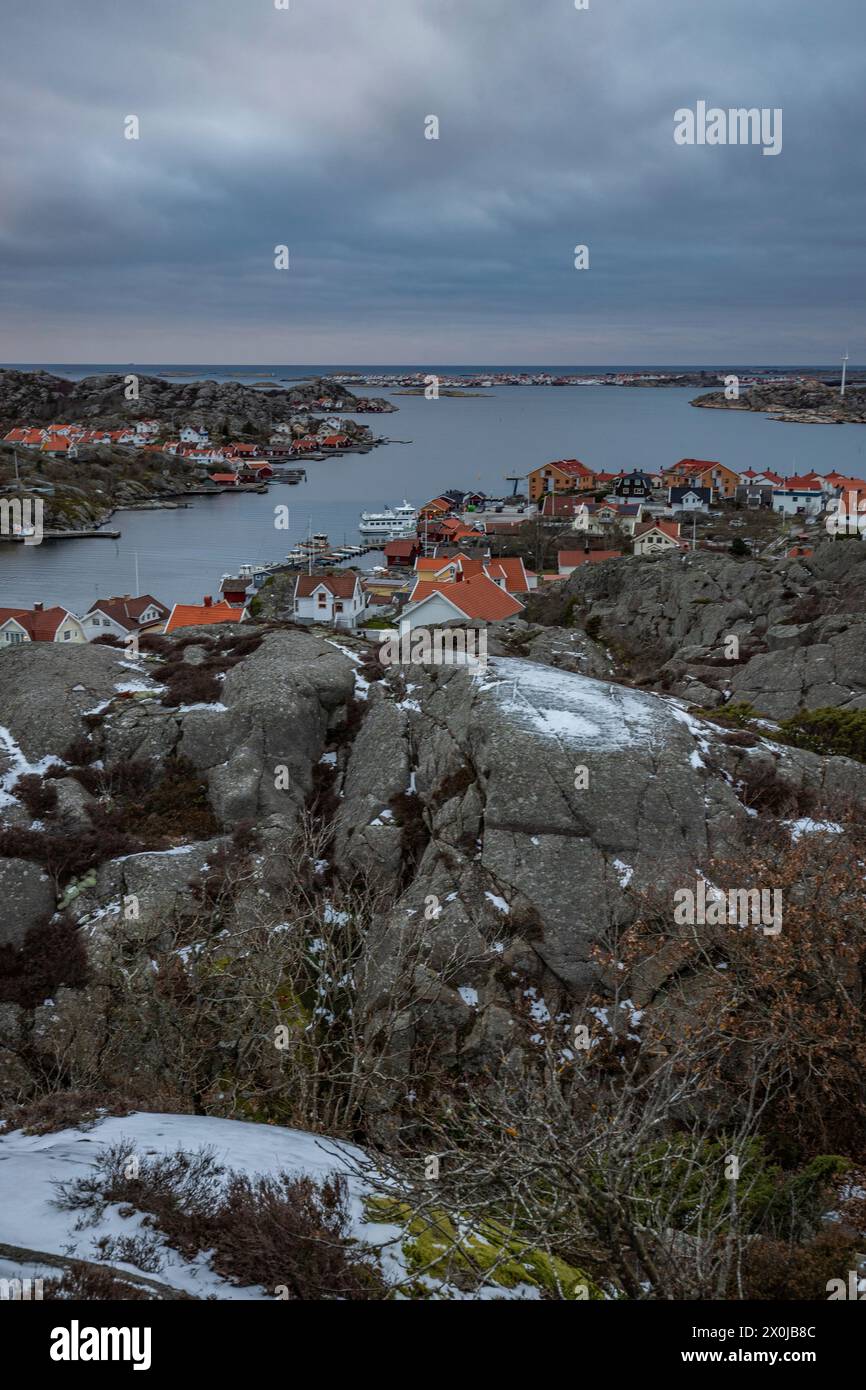 Moulin à vent historique typique en bois rouge dans un paysage hivernal. Le bâtiment est situé sur un rocher sur la côte. Soirée à Stenungsund, Suède Banque D'Images