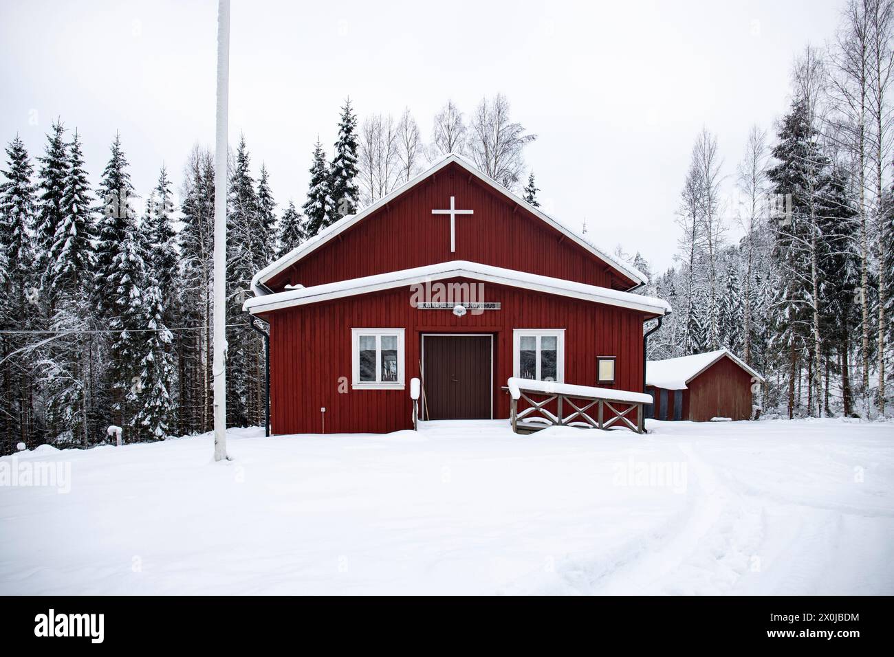 Maison suédoise rouge typique. Maison en bois dans un paysage d'hiver avec de la glace et de la neige. Petite colonie au milieu d'une forêt enneigée. Paysage photographié en Suède Banque D'Images