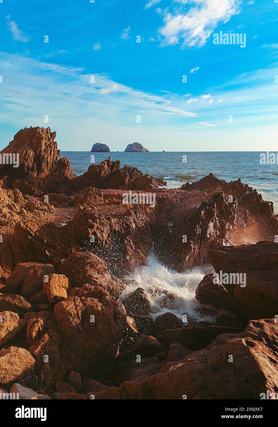 Une vague puissante s'écrasant contre le rivage rocheux, créant une scène énergique et dynamique qui capture la puissance brute et la beauté de l'océan Banque D'Images