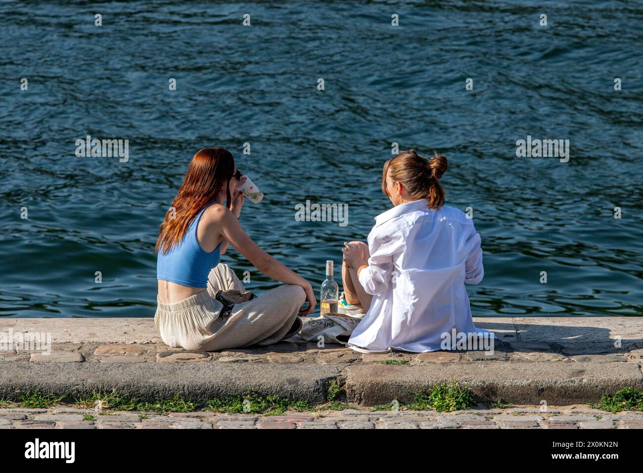 Jeunes assis sur les rives de la Seine, Paris, France Banque D'Images