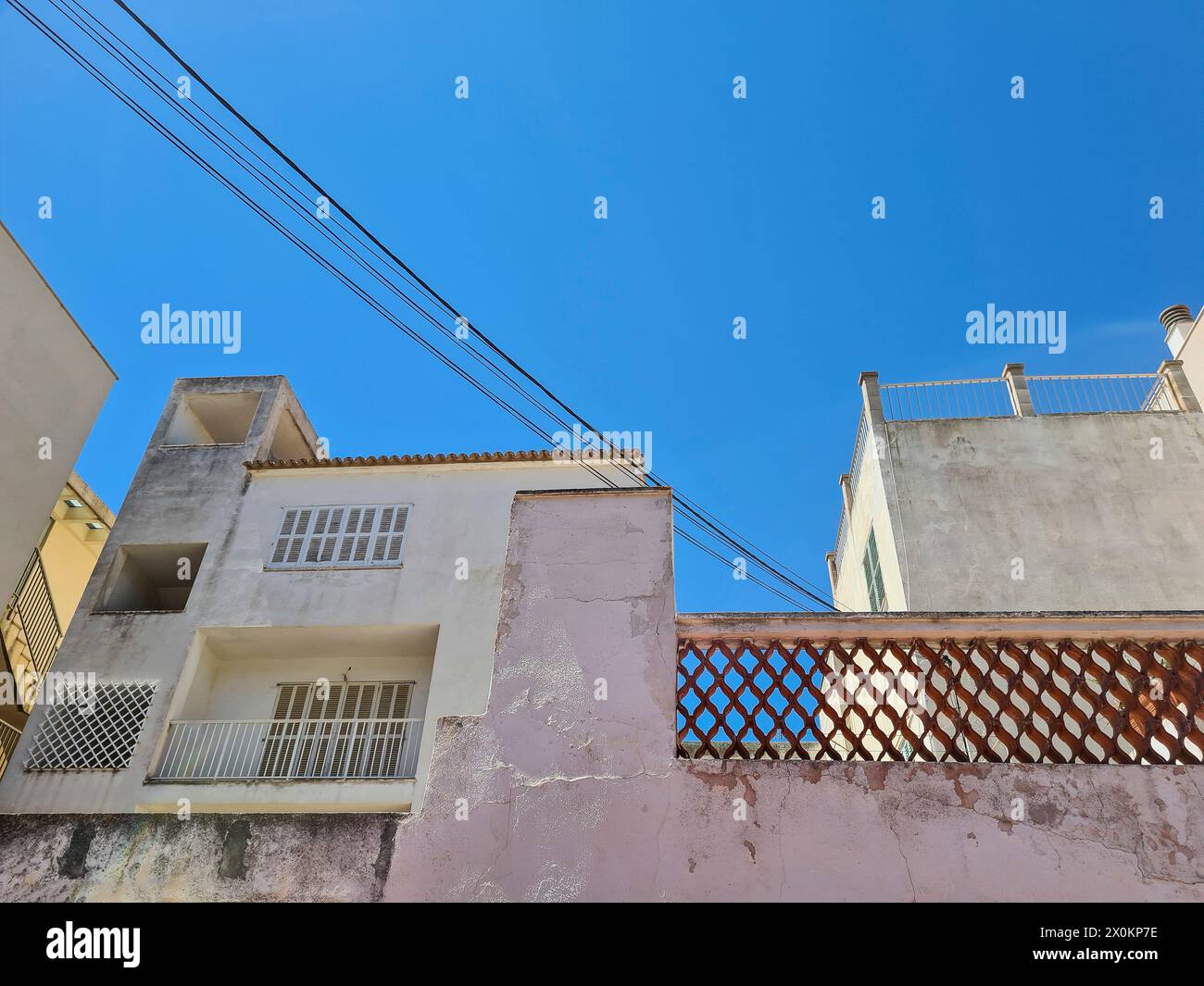 Vue sur la rue vers le haut d'une façade de maison de couleur pastel devant un ciel bleu sur Majorque, Espagne Banque D'Images