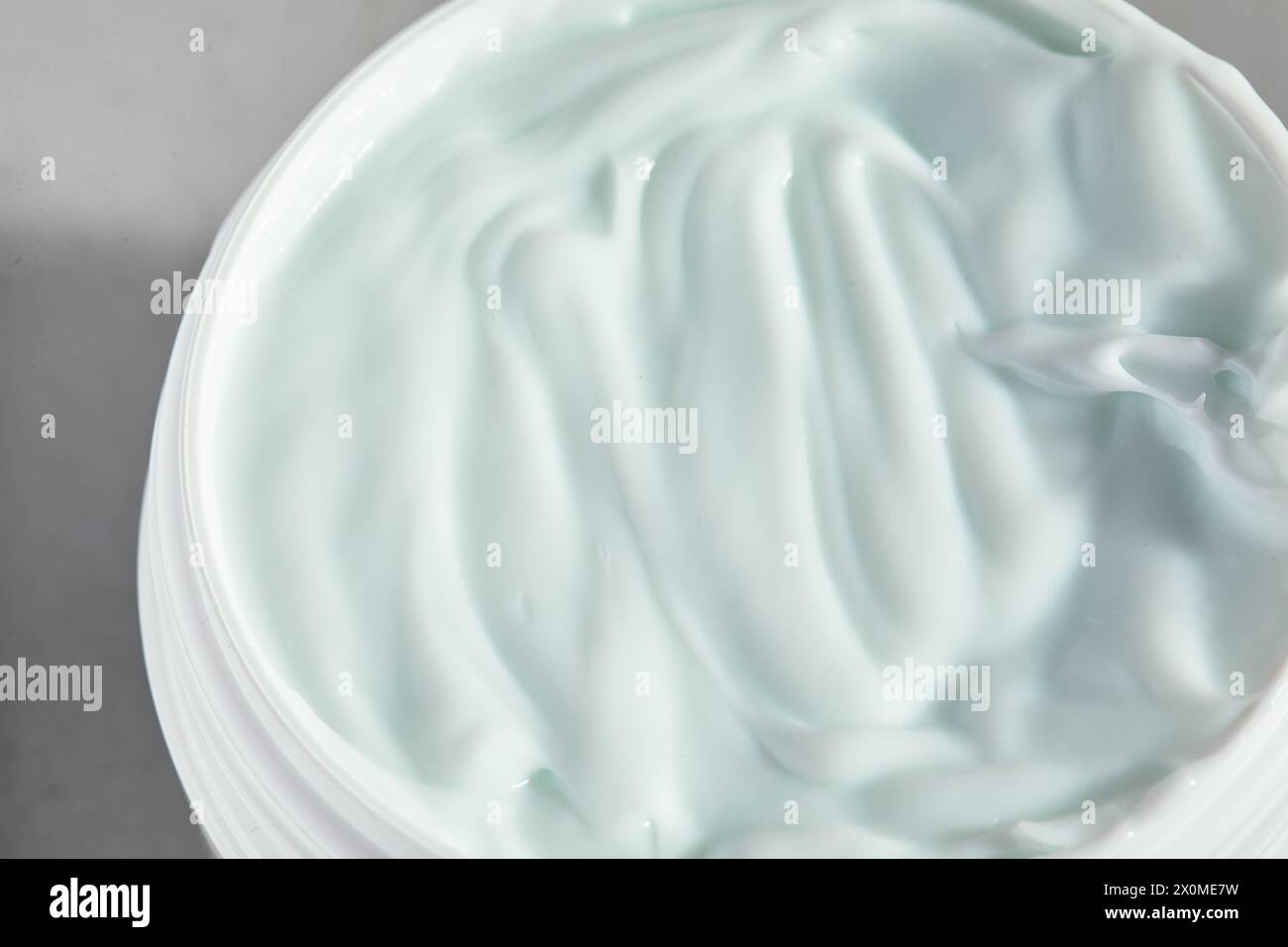 Dose de crème pour le visage dans un bocal. Couvercle enlevé, photo macro d'un fouet hydratant Banque D'Images