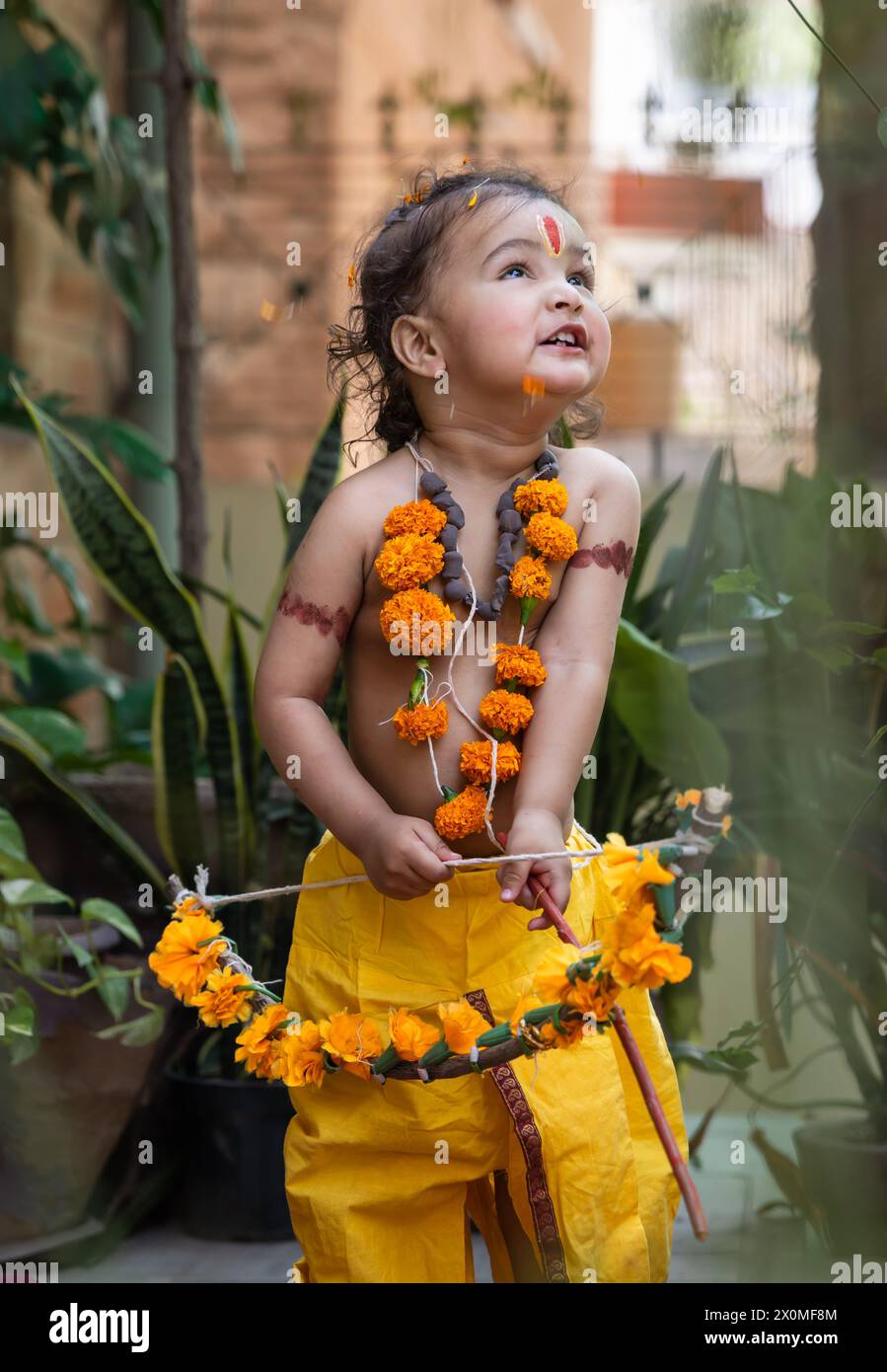 Portrait de mignon garçon indien robes comme seigneur rama avec arc à l'extérieur avec fond flou le jour Banque D'Images