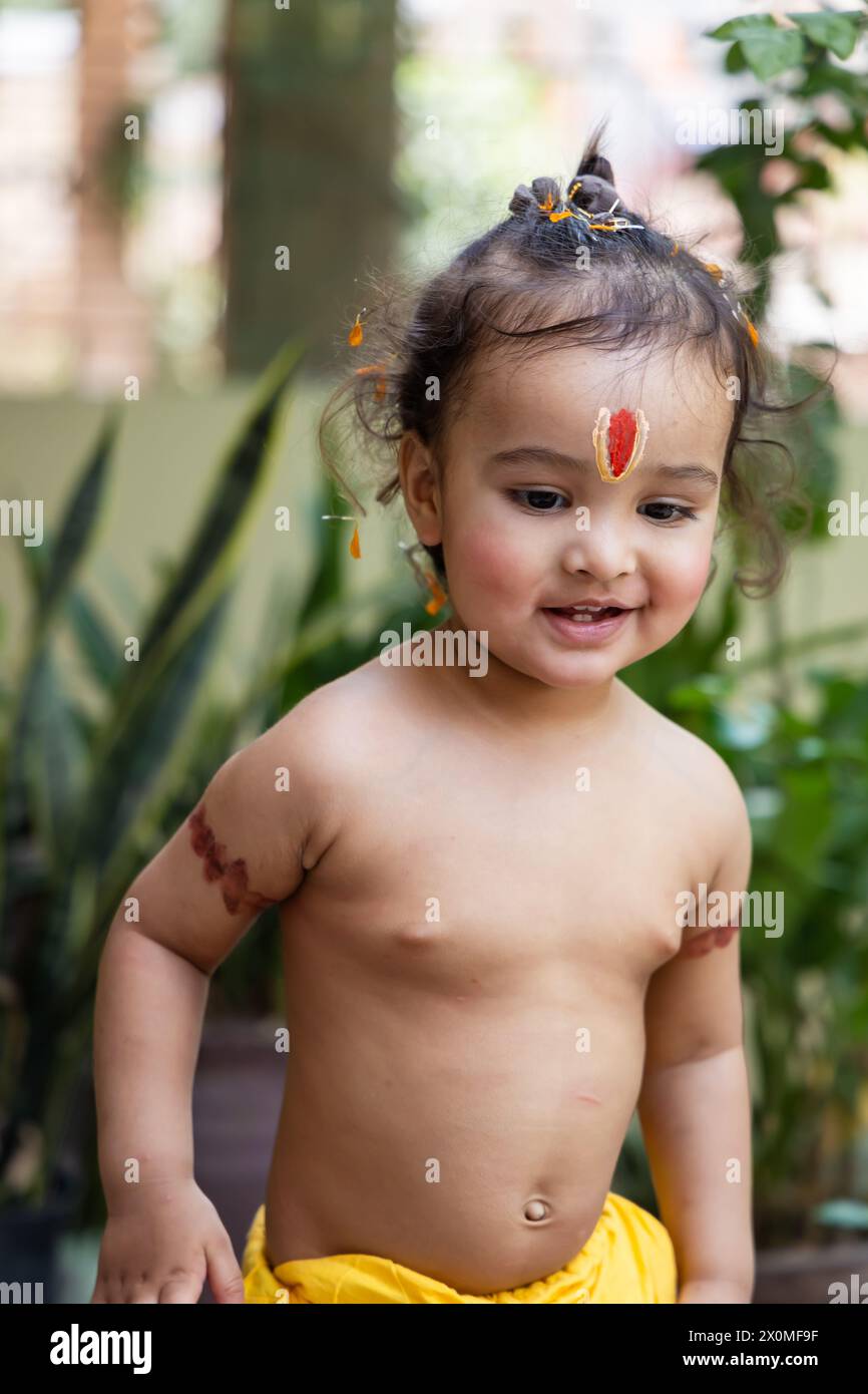 Garçon indien mignon avec symbole religieux sacré sur la tête à l'extérieur avec fond flou Banque D'Images