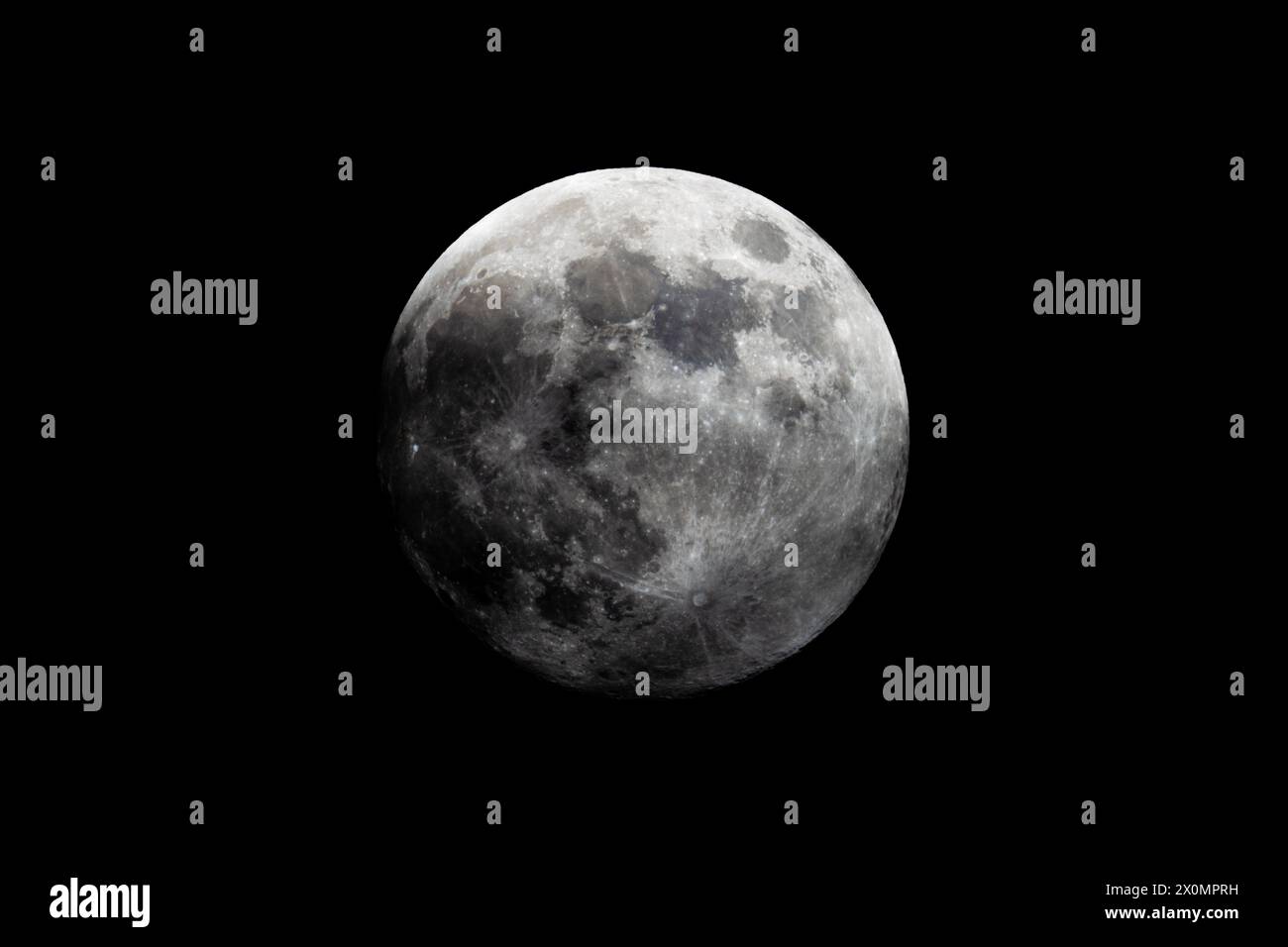 Une photographie en noir et blanc montrant la pleine lune dans le ciel de minuit, sur fond noir foncé. L'objet astronomique brille brillamment, c Banque D'Images