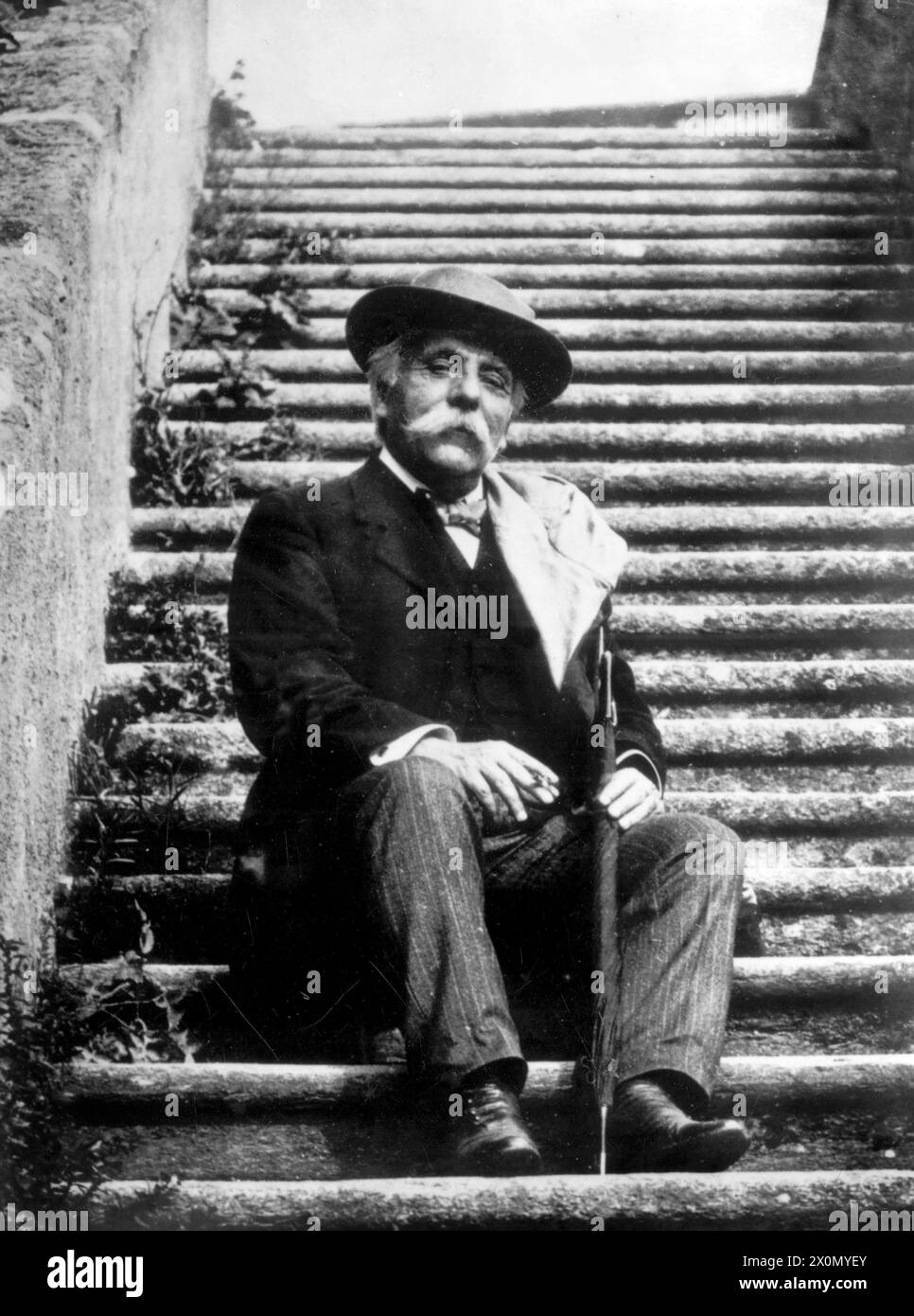 Gabriel Fauré assis sur un escalier, cigarette à la main Banque D'Images