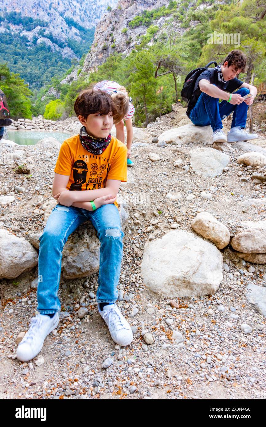 Portrait d'un garçon de 11 ans assis sur un rocher dans le canyon Goynuk près d'Antalya en Turquie Banque D'Images