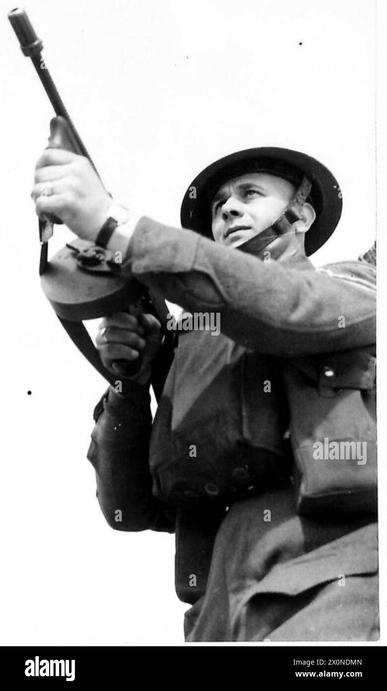 Un soldat du Suffolk Regiment s'entraîne pour des opérations offensives, observant l'activité ennemie tout en manipulant un canon Tommy pendant les exercices. Banque D'Images