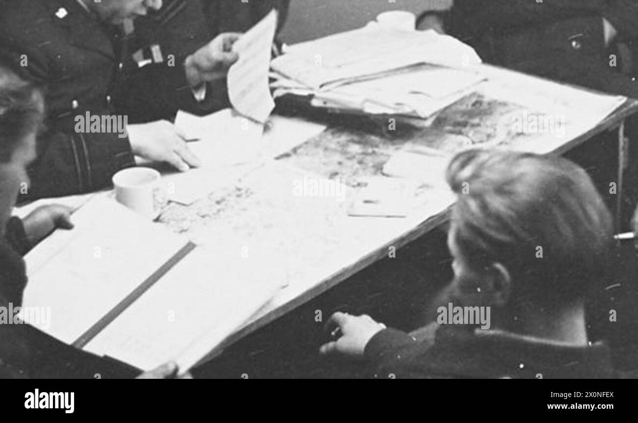 Les équipages de la RAF ont partagé leurs expériences de mission avec un officier du renseignement après un raid à la bombe, mettant en évidence la rétroaction opérationnelle et le soutien au sol pour les bombardiers Halifax. Banque D'Images