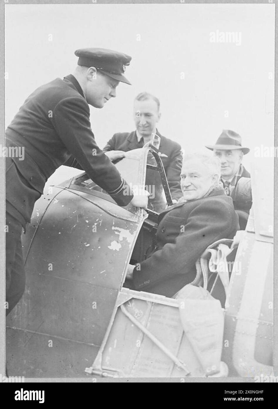 Le Flight Lieutenant T.J. Truscott, le Sergent D. Downes et l'envoyé australien Sir Earle page sont photographiés dans un cockpit de Spitfire lors d'une visite à un escadron de chasse entièrement australien en Grande-Bretagne. Banque D'Images