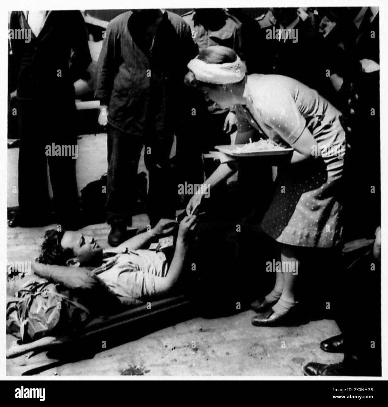 L'ARRIVÉE de B.E.FS À PLYMOUTH - Un tommy britannique blessé sur le quai à Plymouth reçoit des cadeaux d'une femme aide. Négatif photographique, Armée britannique Banque D'Images