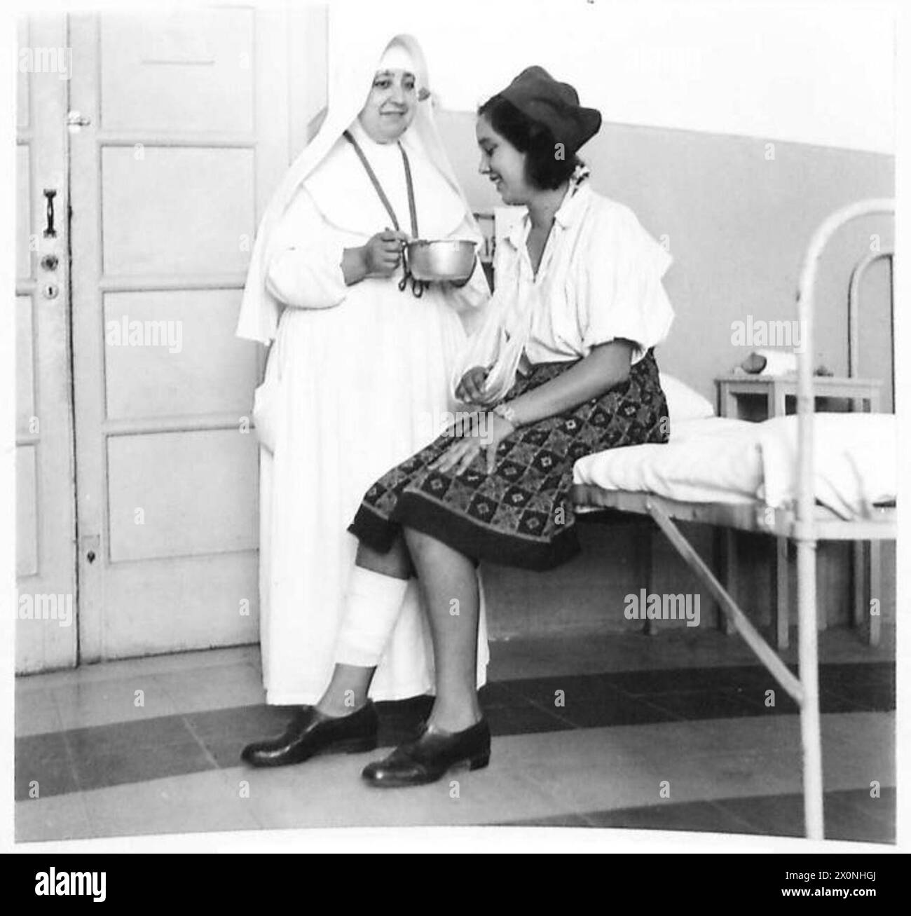 Ksenika Kovacic, dix-huit ans, est photographiée dans un hôpital de la Croix-Rouge italienne avec une sœur italienne de Mercy lors des opérations de l'armée britannique en Italie. Négatif photographique. Banque D'Images
