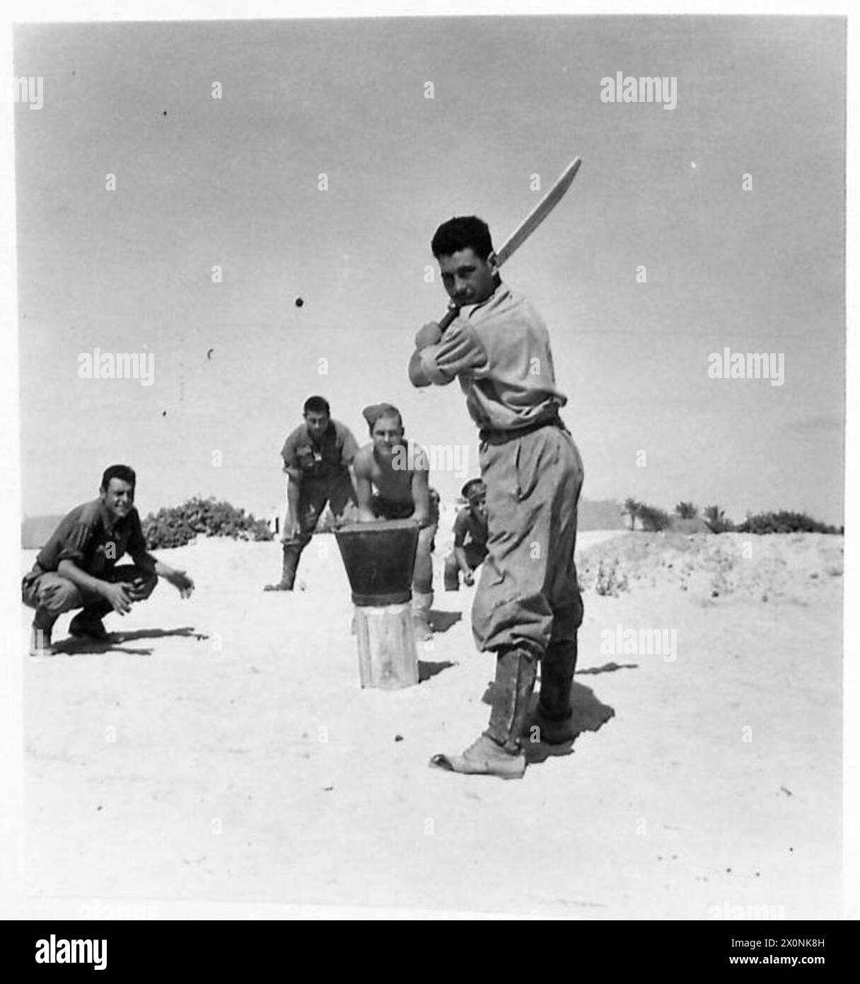 Des prisonniers italiens sont vus jouer au cricket avec les troupes britanniques pendant le temps de repos dans le désert occidental, capturé sur un négatif photographique. Banque D'Images