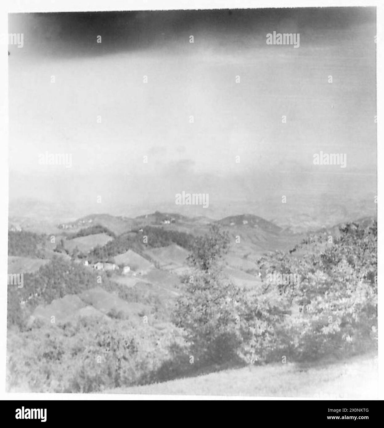 CINQUIÈME ARMÉE : BOMBARDEMENT LOURD AUTOUR DE BOLOGNE - nuages de fumée et de poussière s'élevant à des centaines de pieds alors que les bombardiers larguent leurs charges mortelles. La ville de Formiche peut être vue sur la colline devant le nuage de fumée. Négatif photographique, Armée britannique Banque D'Images