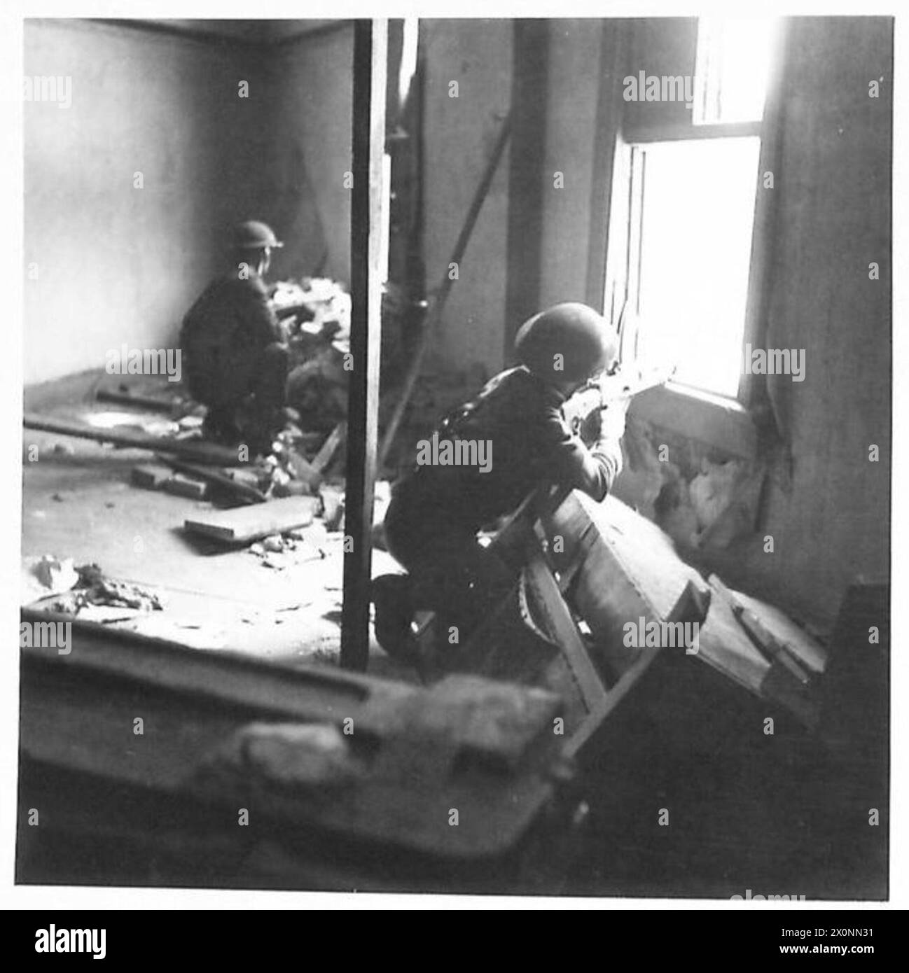 Les troupes britanniques mènent un exercice de combat de rue à Londres, avec des artilleurs Bren fournissant le soutien des fenêtres et de l'infanterie avançant dans les rues. Banque D'Images