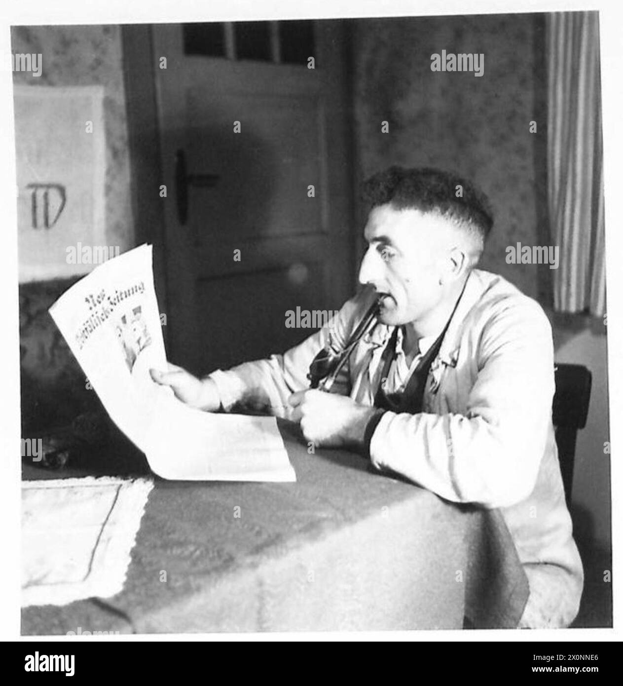 Un mineur de charbon nord-allemand prend une pause pour fumer et lire un journal sur le site de contrôle du charbon. Banque D'Images