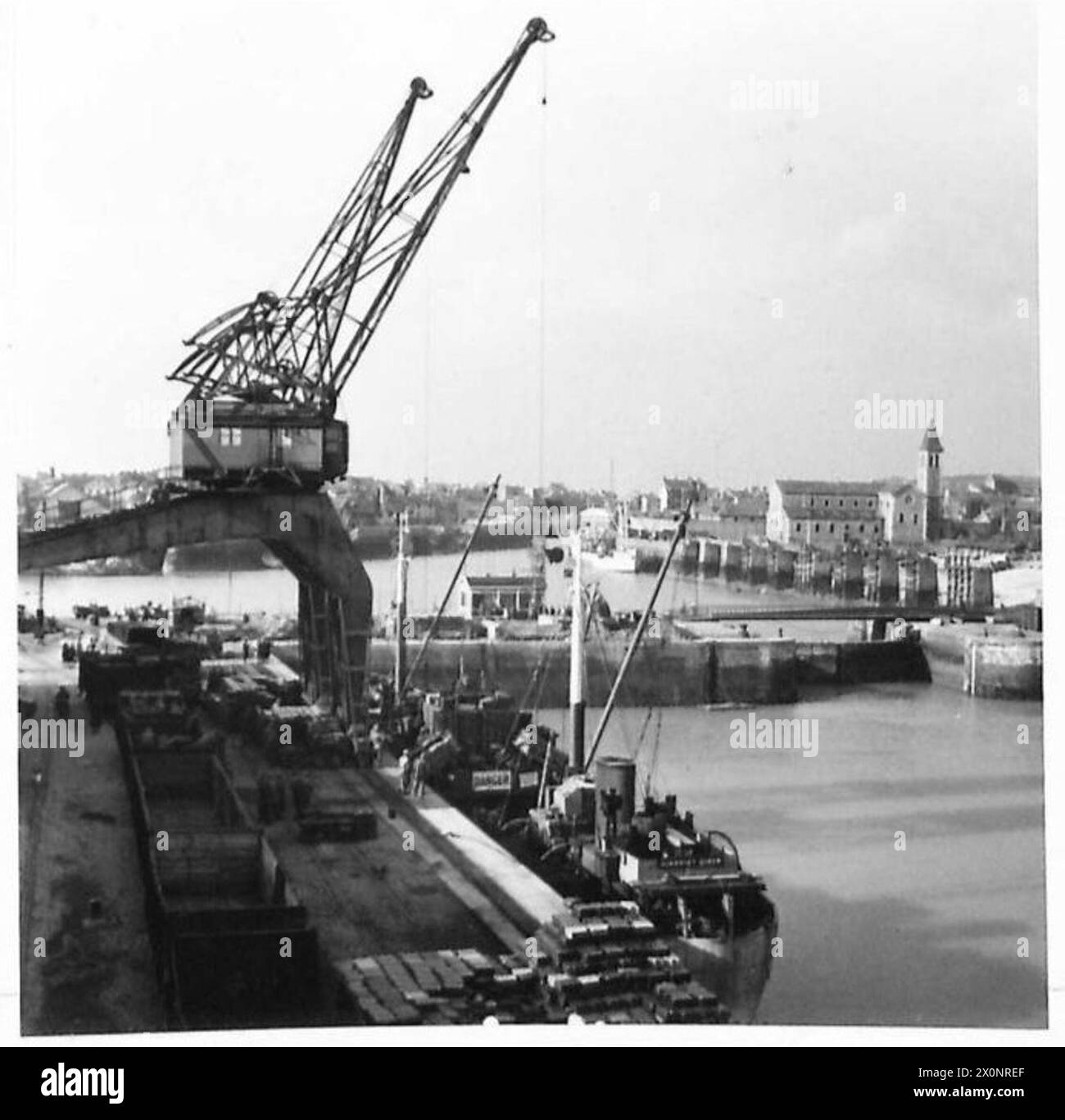 Photographie négative montrant des vues panoramiques du port de Dieppe avec les ingénieurs royaux de la 2e armée chargeant des magasins et des fournitures pour les forces britanniques, 21e groupe d'armées. Banque D'Images