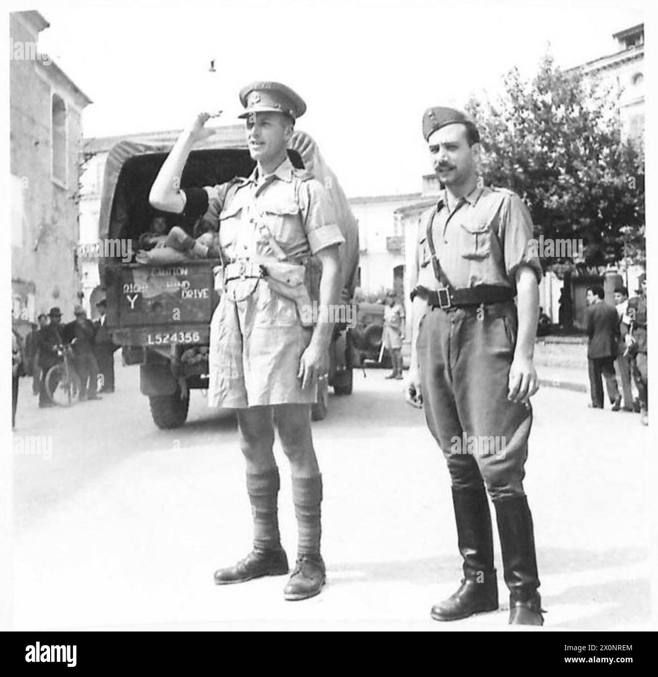 La police militaire britannique dirige le trafic et prend le contrôle des routes pendant l'invasion de la Sicile par la 8e armée, avec des carabiniers italiens observant. Banque D'Images