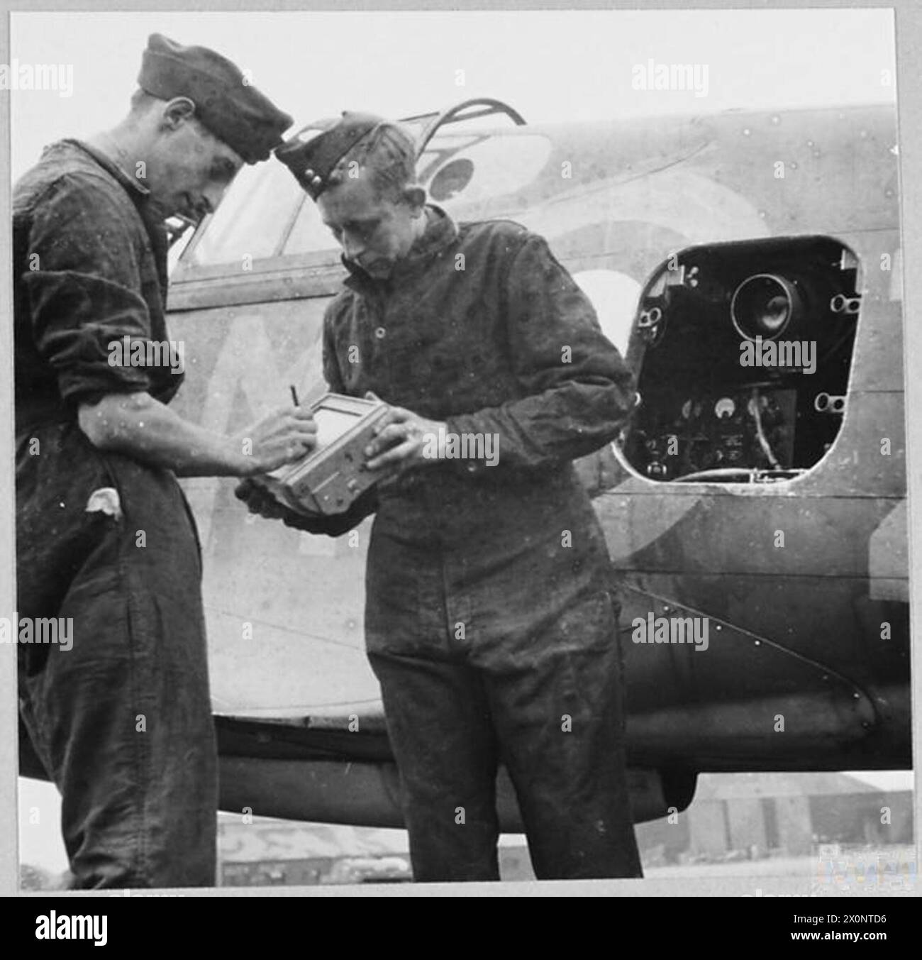 Les aviateurs de la section photographique de l'escadron no 26 de la RAF enregistrent les données d'une caméra aérienne de type F.24 sur un Curtiss Tomahawk à Gatwick, Sussex, pendant un entraînement de reconnaissance tactique entre 1940 et 1943. Banque D'Images