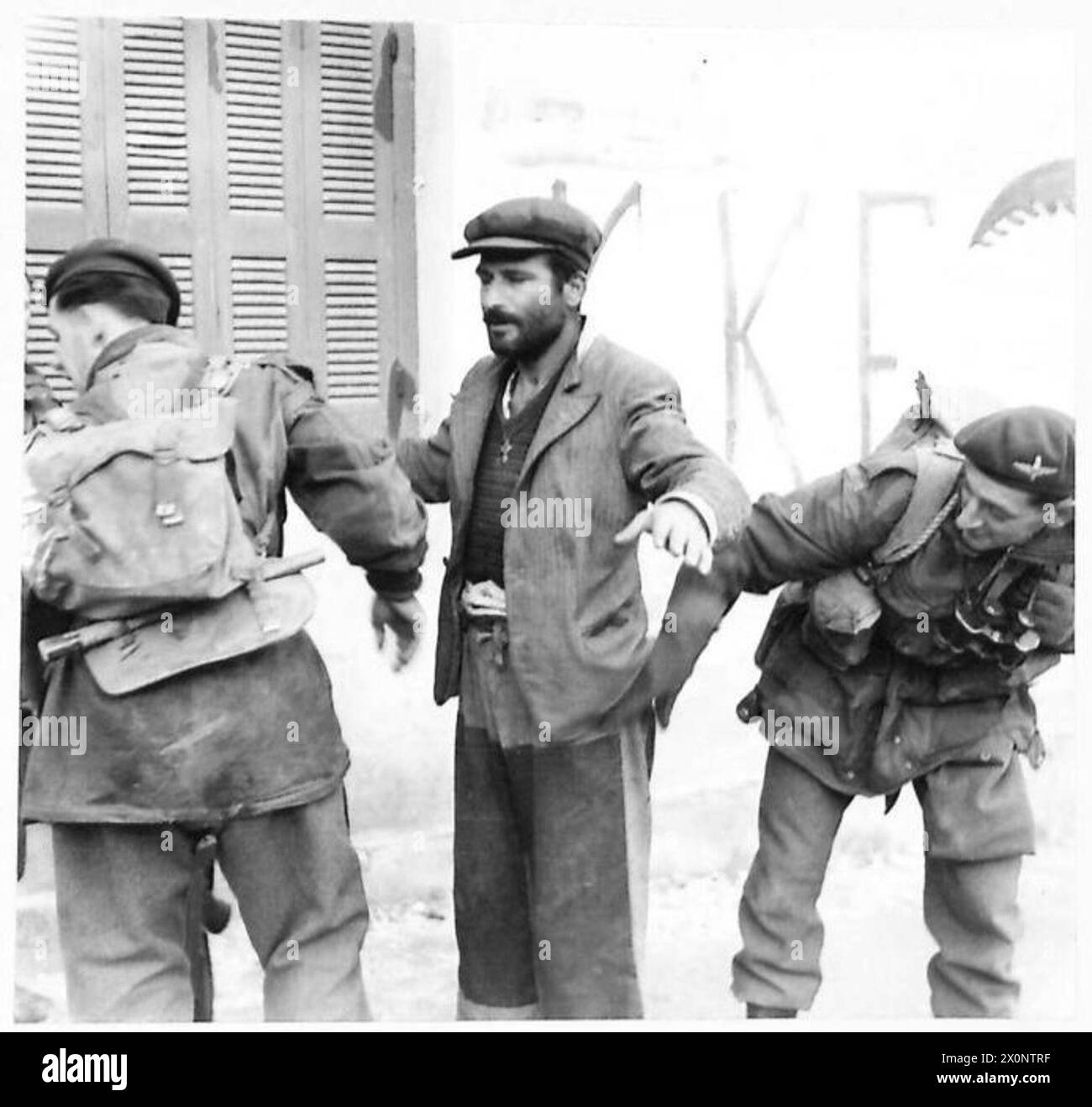 Deux parachutistes fouillent un suspect civil à Athènes. Négatif photographique de l'armée britannique. Banque D'Images