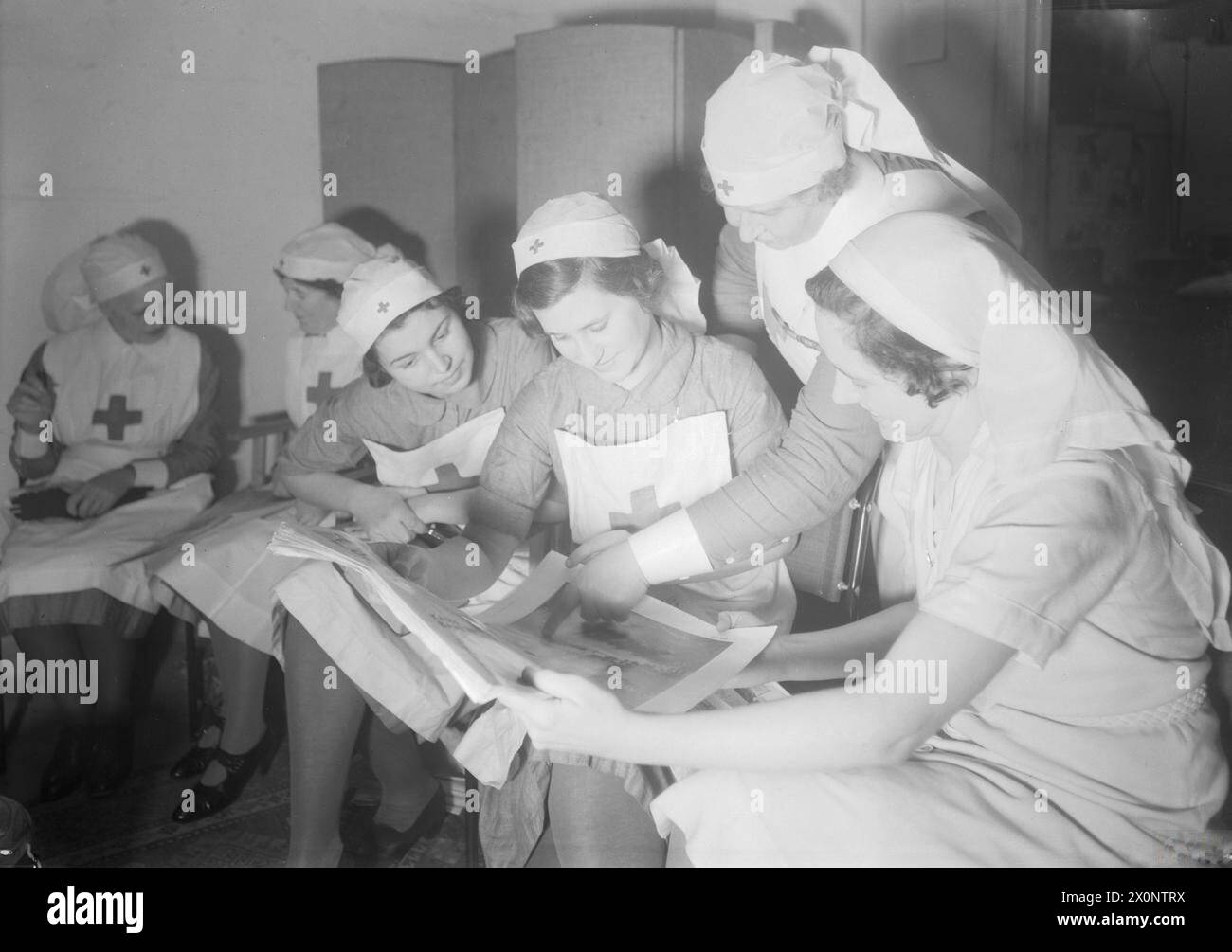 Précautions contre les raids AÉRIENS À KINGSTON HOUSE, KNIGHTSBRIDGE, LONDRES, ANGLETERRE, C 1940 - Un groupe d'infirmières lit des magazines pendant qu'elles se détendent au centre ARP à Kingston House, Knightsbridge Banque D'Images