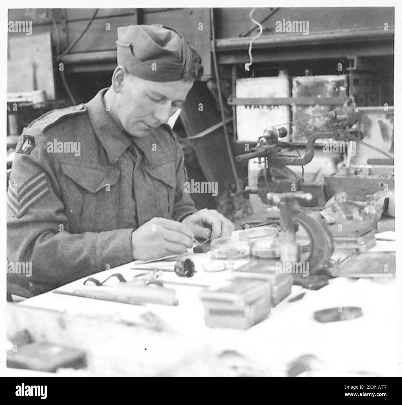 Le sergent F.J. Elliot de Green Farm, Newbold, Chesterfield, Derby, manipule un petit mécanisme nécessitant une réparation dans un atelier REME de la 8e armée. Banque D'Images