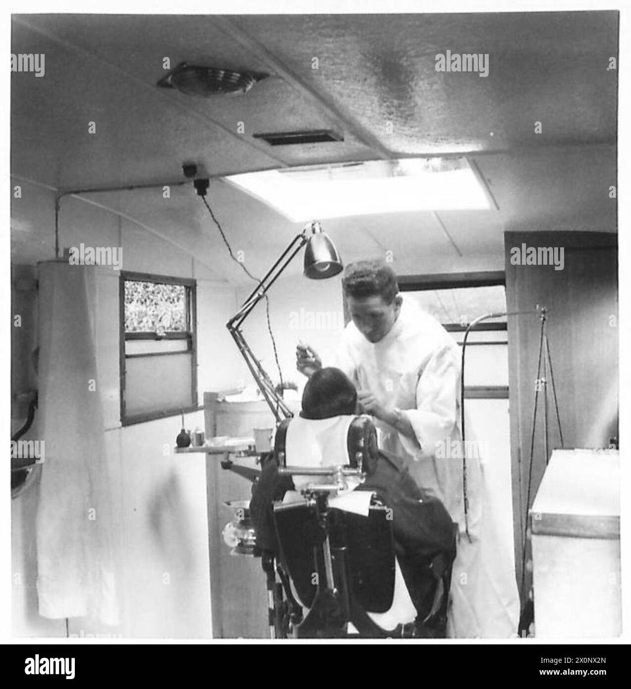 L'intérieur d'un fourgon dentaire mobile est représenté avec un patient recevant un traitement dentaire. Banque D'Images