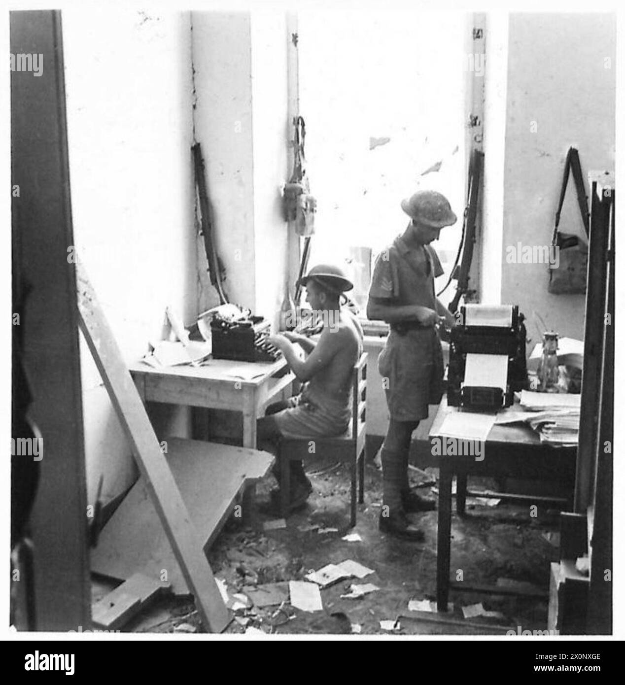 L'éditeur exploite une presse rotative pendant que son assistant tape, produisant la publication Tobrouk Truth. Négatif photographique, armée britannique. Banque D'Images