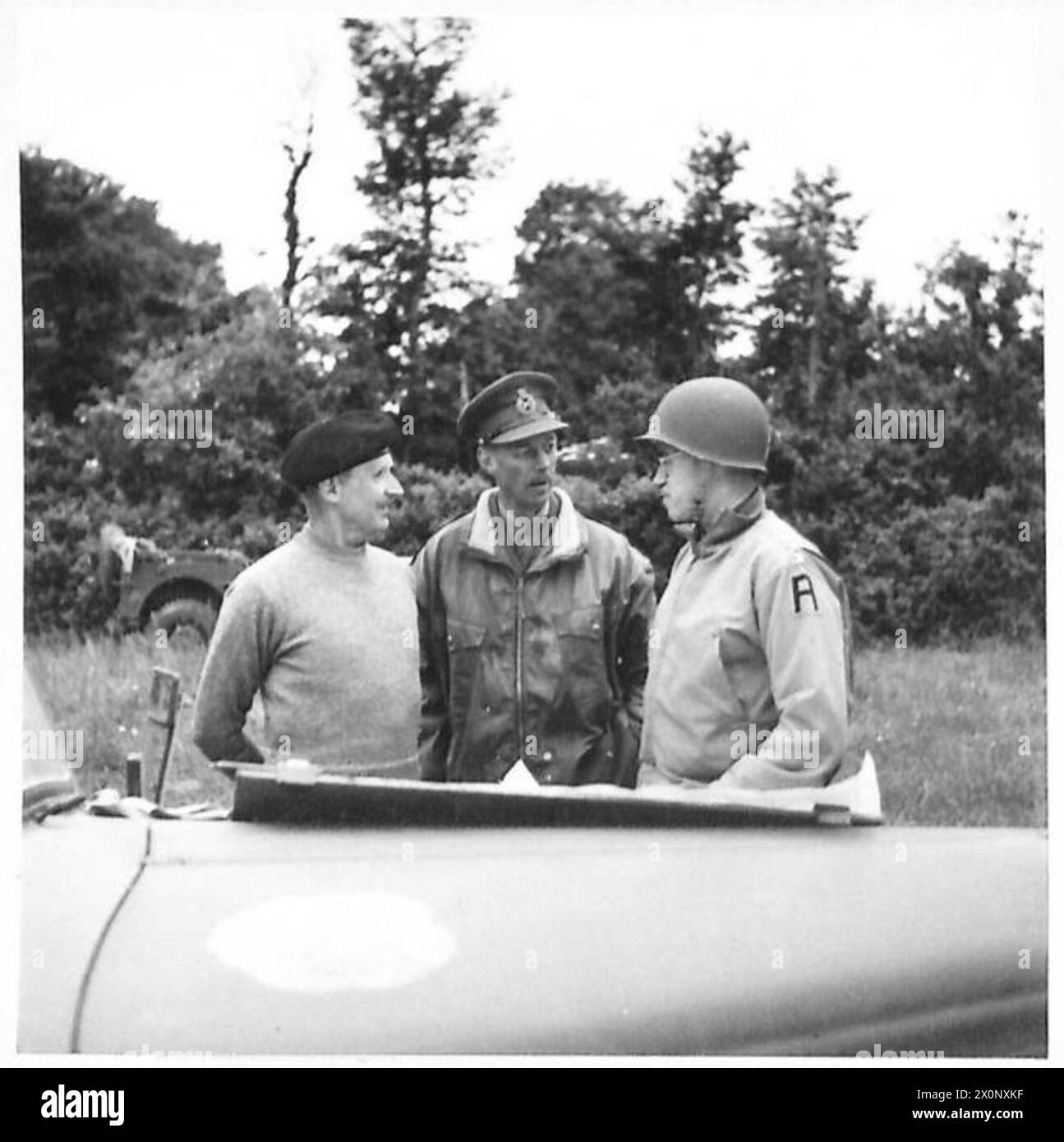FORCES ALLIÉES DANS LA CAMPAGNE DE NORMANDIE 1944 - le général Sir Bernard Montgomery, lieutenant-général Miles Dempsey (au centre), commandant la seconde armée britannique et le lieutenant-général Omar Bradley (à droite), commandant la première armée américaine, consultez une carte sur le capot de la voiture d'état-major de Monty, près de Port-en-Bessin, le 10 juin 1944 Banque D'Images