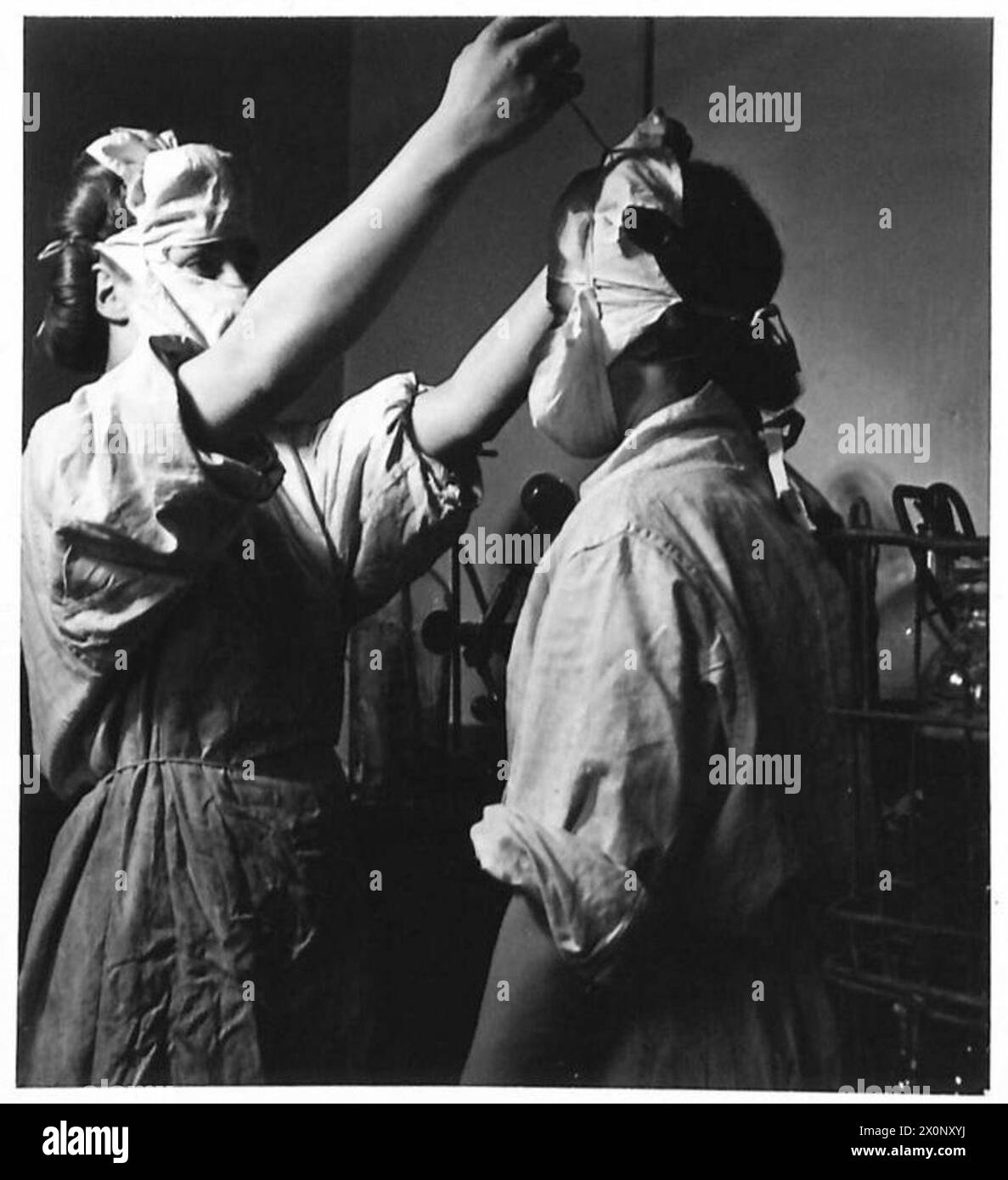 LE SERVICE DE TRANSFUSION SANGUINE DE L'ARMÉE - ATS mettant des blouses stériles et des masques avant d'entrer dans la salle stérile. Noms : Ptes. Coleman et Skimmins, ATS. Négatif photographique, Armée britannique Banque D'Images