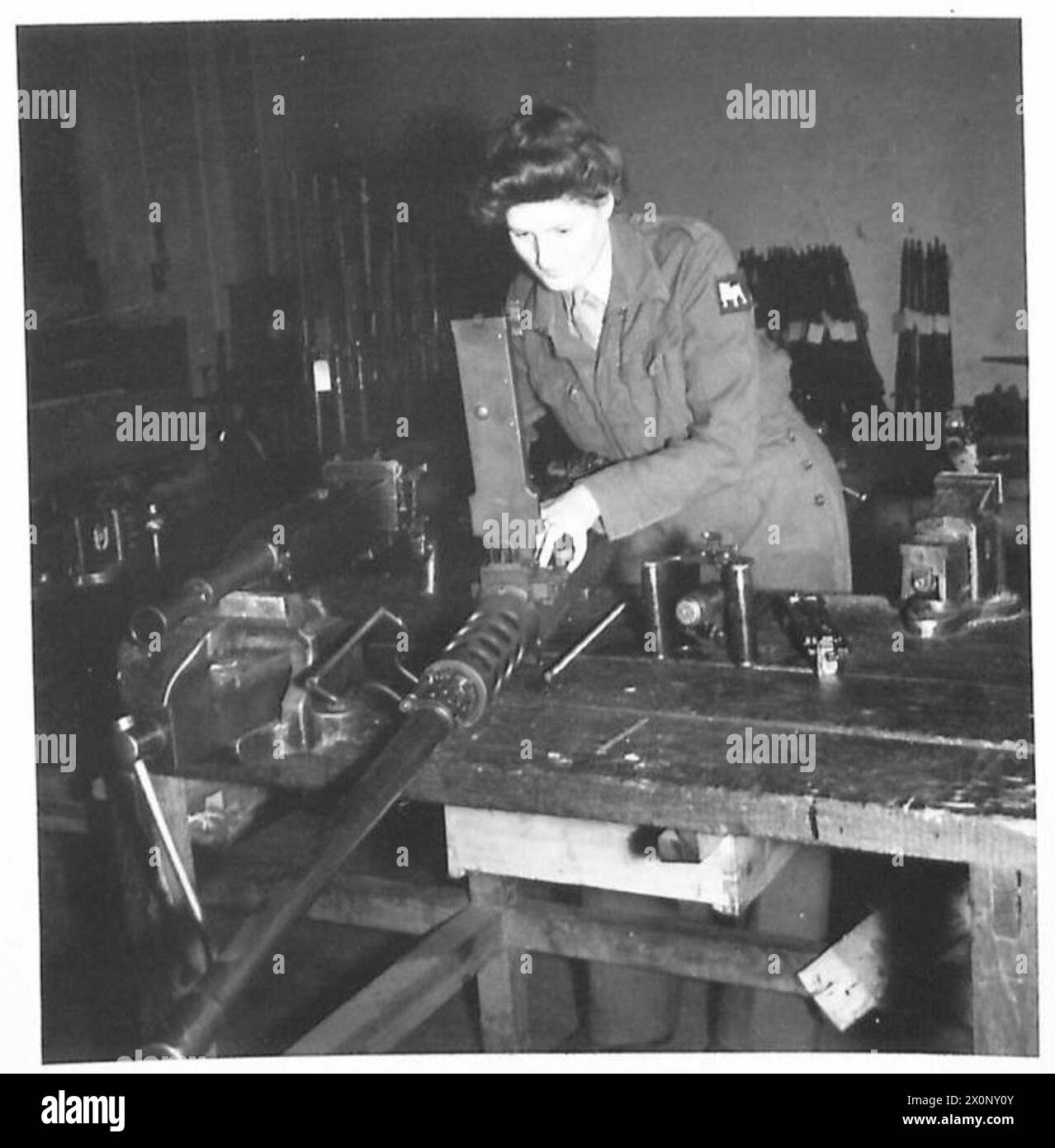 Le soldat H. Hornsby, armurier dans les ateliers R.E.M.E. travaille sur une mitrailleuse Browning 5. Le négatif photographique documente l'activité de maintenance. Banque D'Images