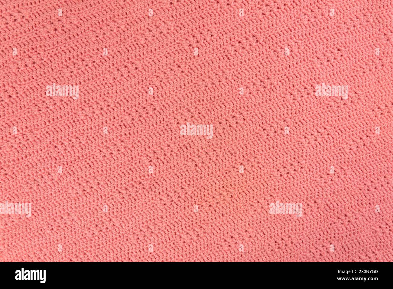 Texture et motif d'un pull tricoté en laine rose. Fond de tissu de laine chaud fait à la main. Banque D'Images