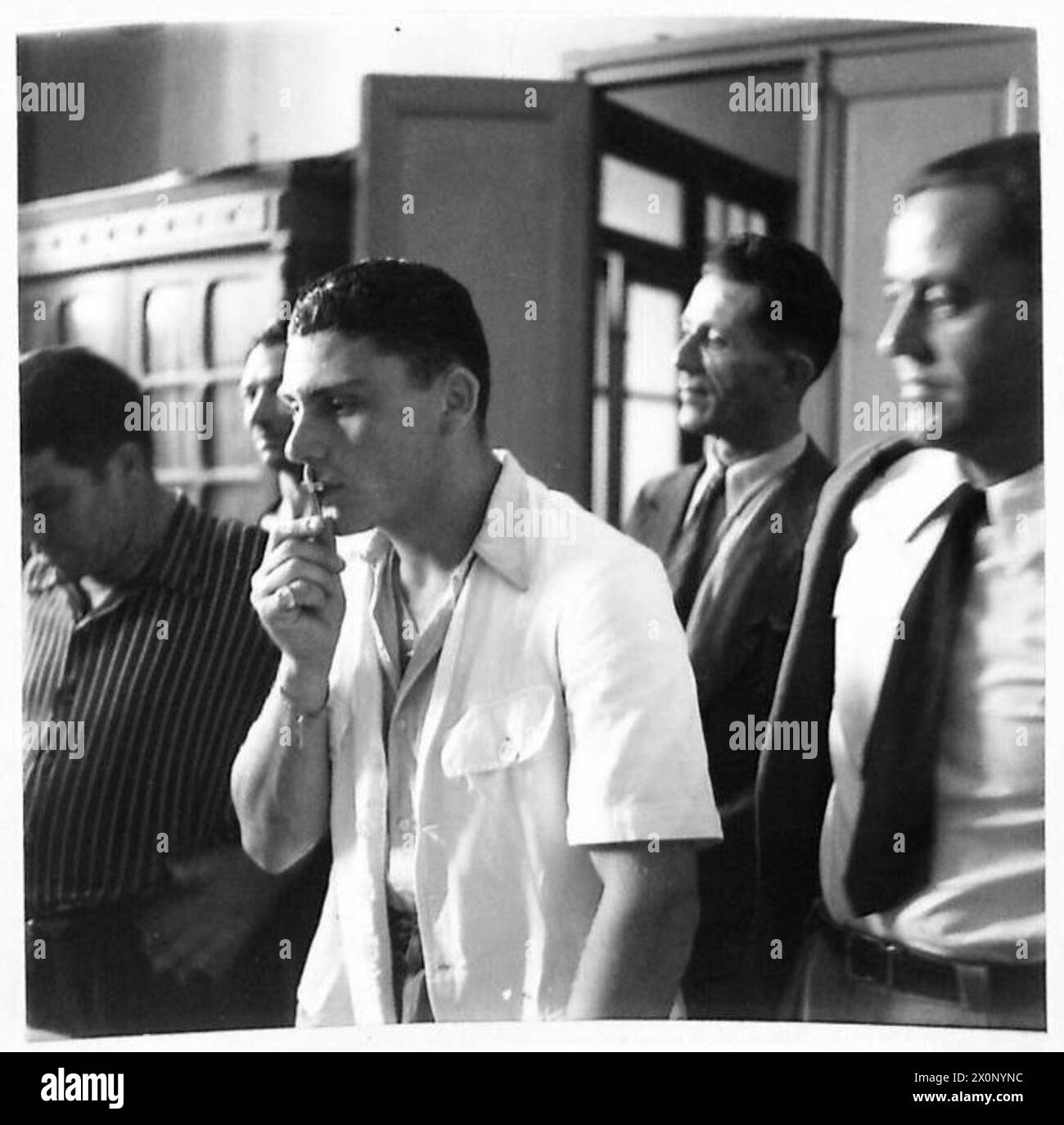 Négatif photographique montrant des recrues maltaises en Afrique du Nord prenant part à des procédures d'enrôlement, y compris l'acte cérémoniel d'embrasser la croix, pour servir avec les Alliés. Banque D'Images