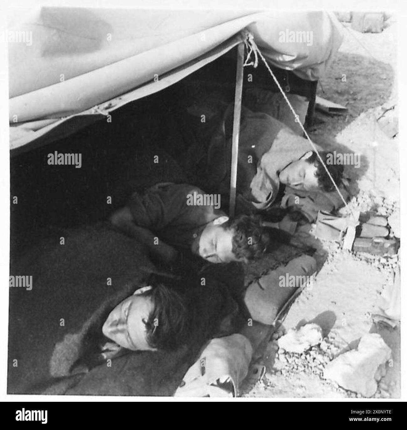 Un JOUR DANS LA VIE D'Un ÉQUIPAGE DE CHARS - la patrouille, le char retourne à sa base avancée, et les membres fatigués de son équipage se retournent après un bon repas. Les nuits sont longues dans le désert pendant l'hiver, et comme aucune lumière d'aucune sorte ne peut être montrée, il n'y a rien d'autre à faire que retourner, peut-être dès 18 heures. En tout cas, le lit est l'endroit le plus chaud. Négatif photographique, Armée britannique Banque D'Images