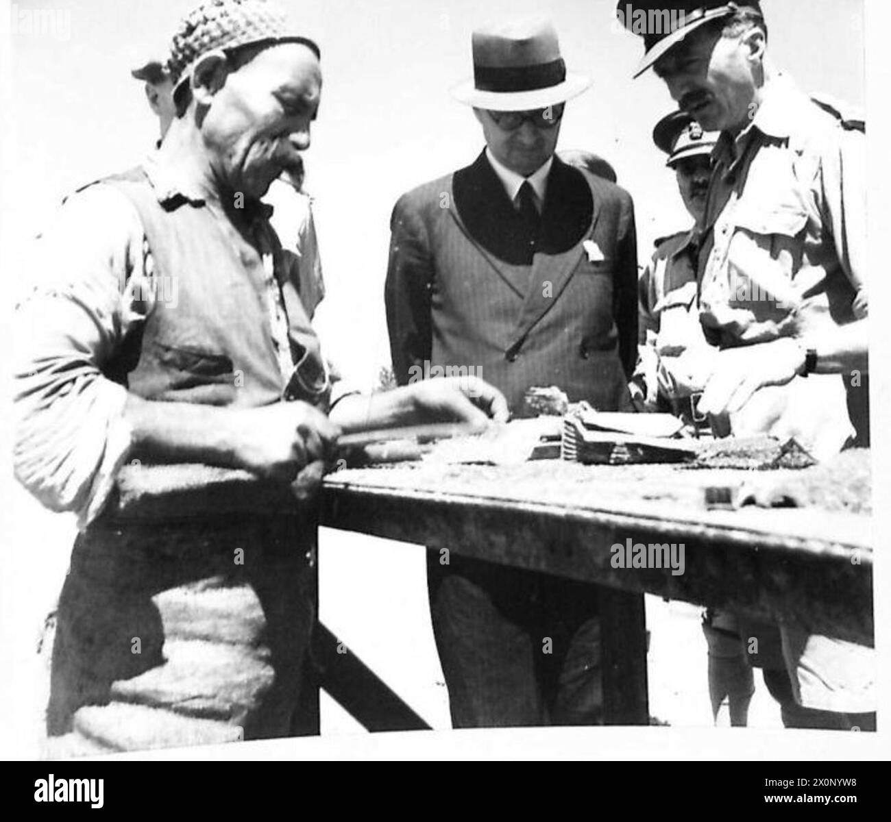 Sir James observe un ouvrier arabe qui nettoie de vieilles cellules de batterie électrique pour récupérer le plomb en Afrique du Nord. Négatif photographique, armée britannique. Banque D'Images Sir James observe un ouvrier arabe qui nettoie de vieilles cellules de batterie électrique pour récupérer le plomb en Afrique du Nord. Négatif photographique, armée britannique. Banque D'Images