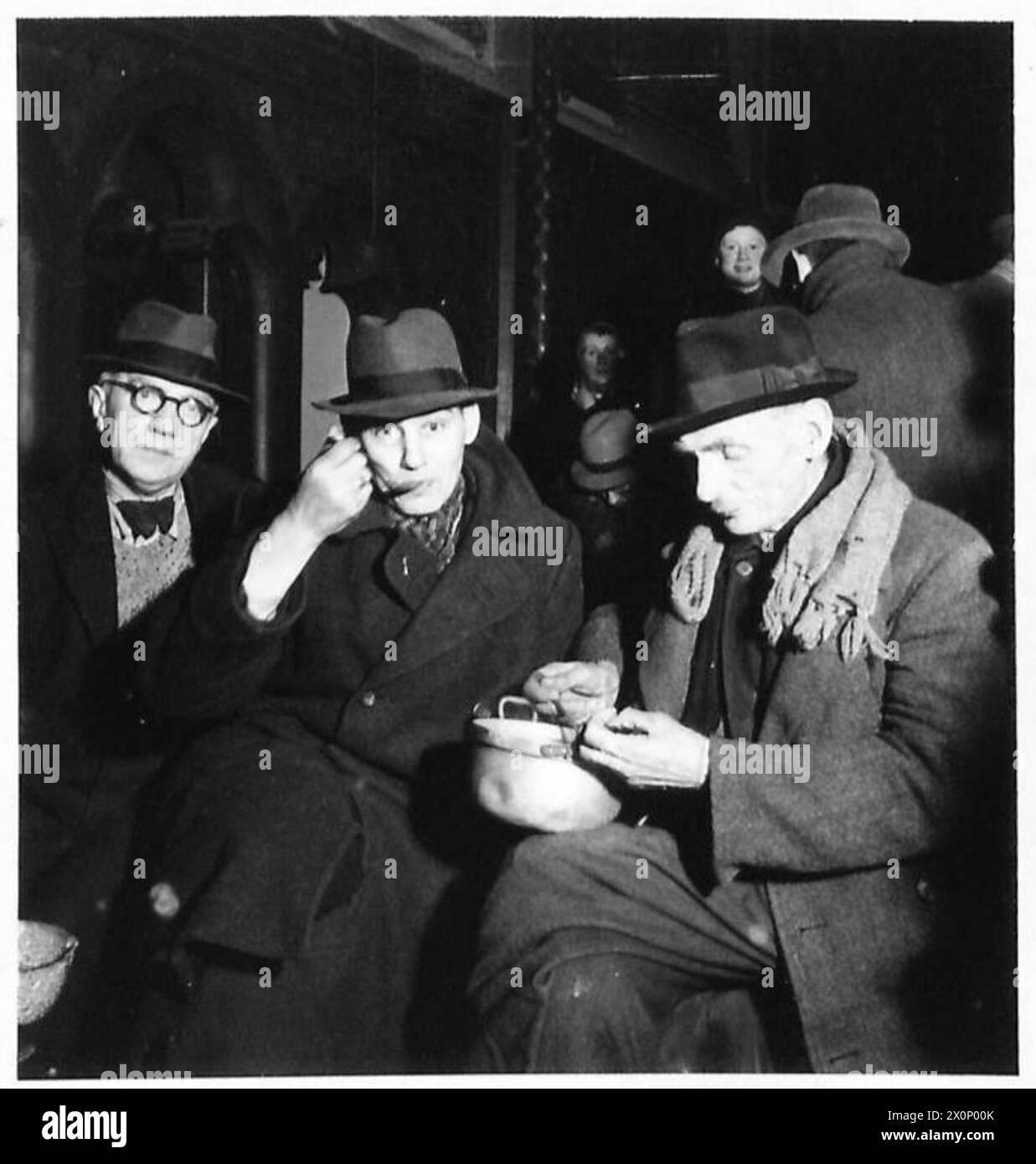 Russes, Polonais et Italiens, auparavant soumis au travail forcé en Allemagne nazie, sont libérés par le 30e corps britannique et prennent un repas chaud dans une église de Materborn. Banque D'Images