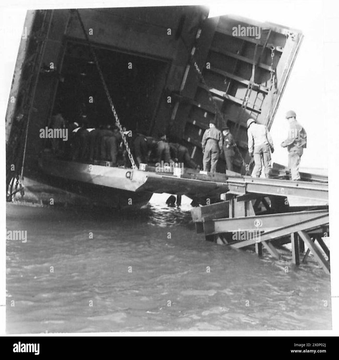 Une rampe portuaire préfabriquée est fixée pour permettre le déchargement des wagons-citernes des navires de débarquement, soutenant les opérations amphibies en Normandie. Banque D'Images Une rampe portuaire préfabriquée est fixée pour permettre le déchargement des wagons-citernes des navires de débarquement, soutenant les opérations amphibies en Normandie. Banque D'Images