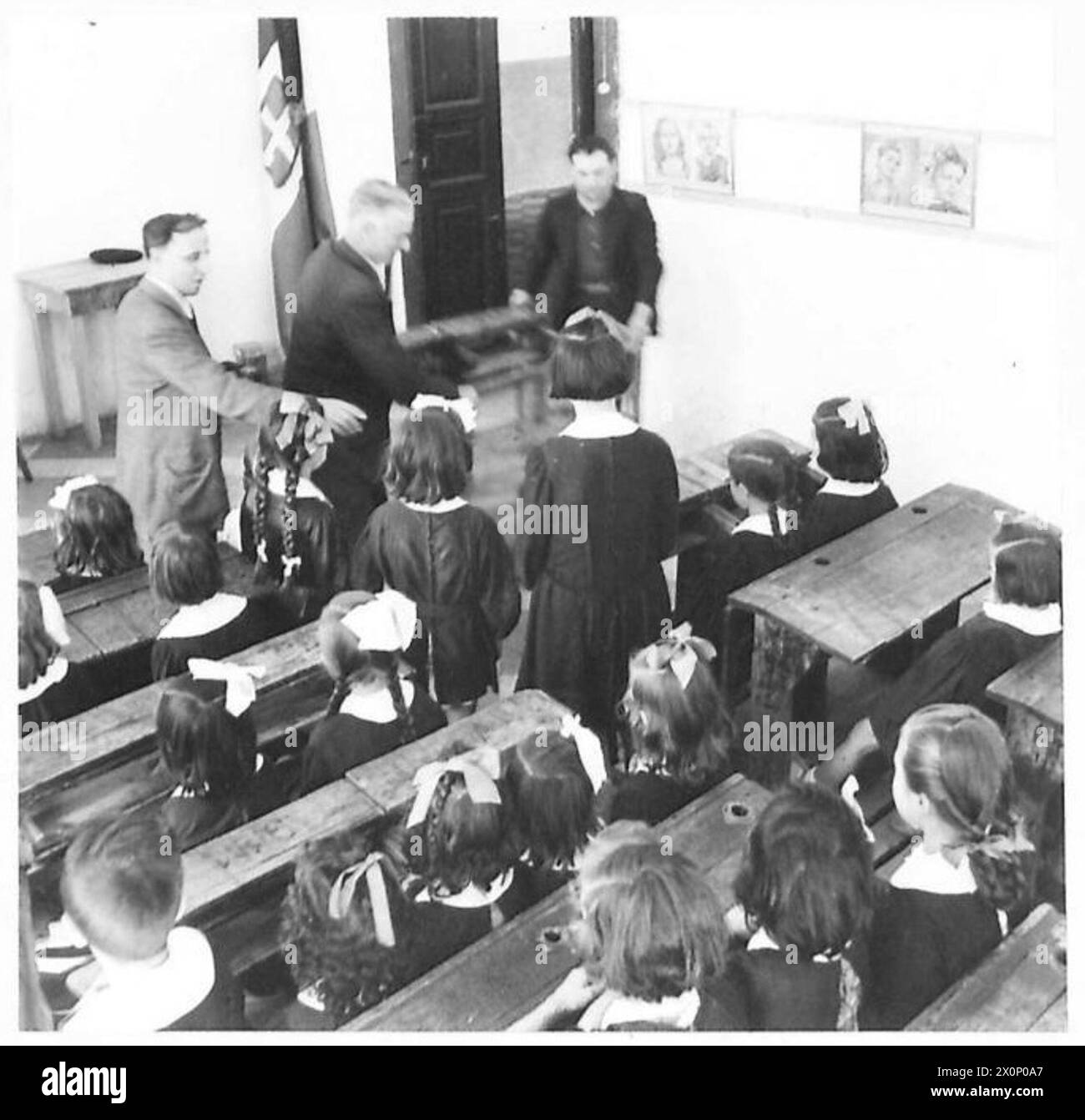 En Italie occupée par les Alliés, les enfants reprennent leurs études après trois ans. À Apricena, les bureaux jetés sont passés sur le chemin de l'école. Les emblèmes fascistes et les portraits sont supprimés, remplacés par le portrait de la reine. Les uniformes de style militaire sont jetés. Documents photographiques négatifs réouverture des écoles et restauration de l'éducation normale. Banque D'Images