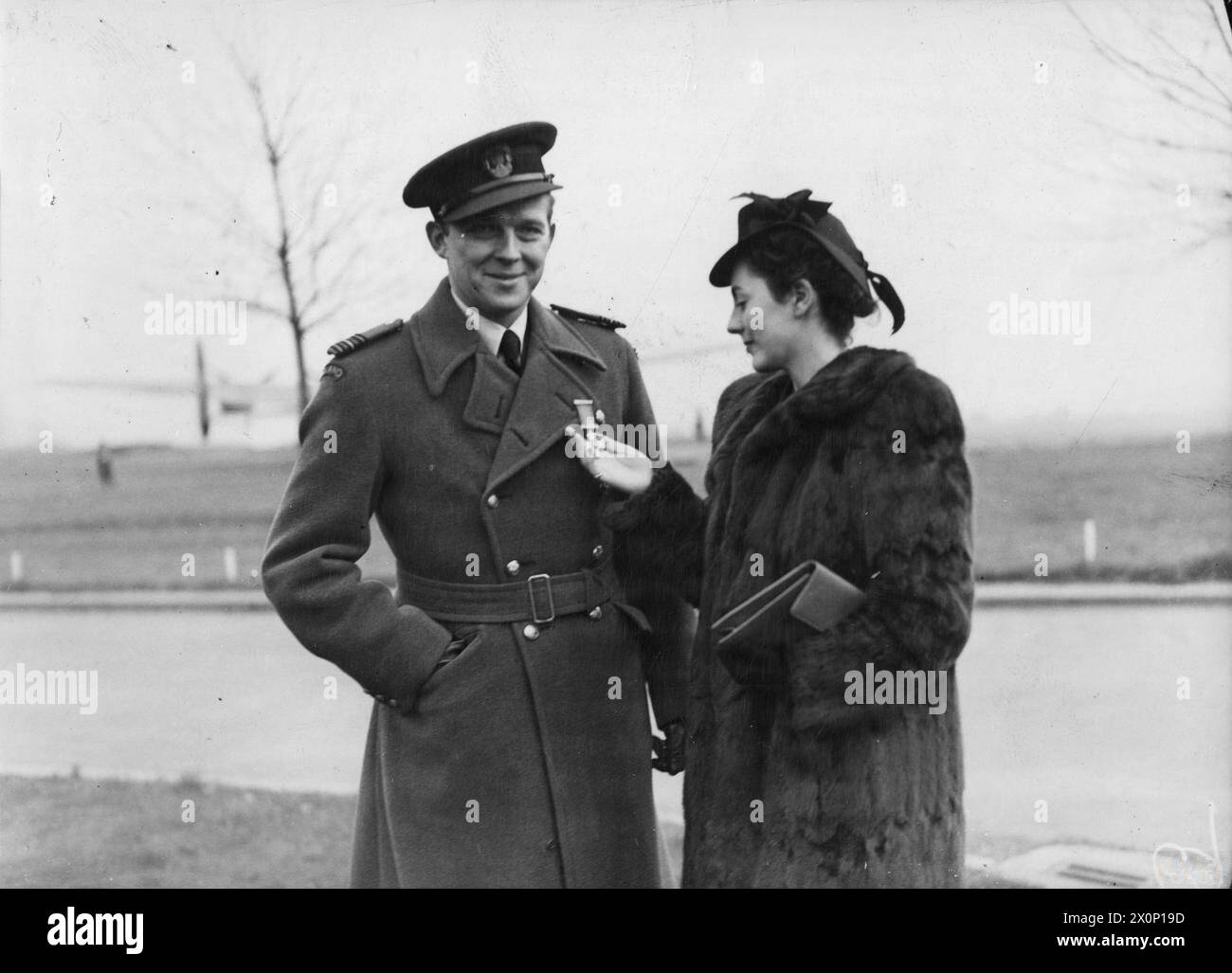 L'ARMÉE DE L'AIR POLONAISE EN GRANDE-BRETAGNE, 1940-1947 - Miss Elizabeth Bullimore de Cuckfield, Sussex, qui a été attaquée au commandant de l'escadre Aleksander Gabszewicz, le commandant de l'escadre no 131 (polonais), regardant le DSO de son fiancé à la RAF Northolt, le 16 novembre 1943. Trois pilotes de chasse polonais ont été décorés de Distinguished Service Orders ce jour-là de l'armée de l'air polonaise, Gabszewicz, Aleksander Klemens, Bullimore, Elizabeth Banque D'Images