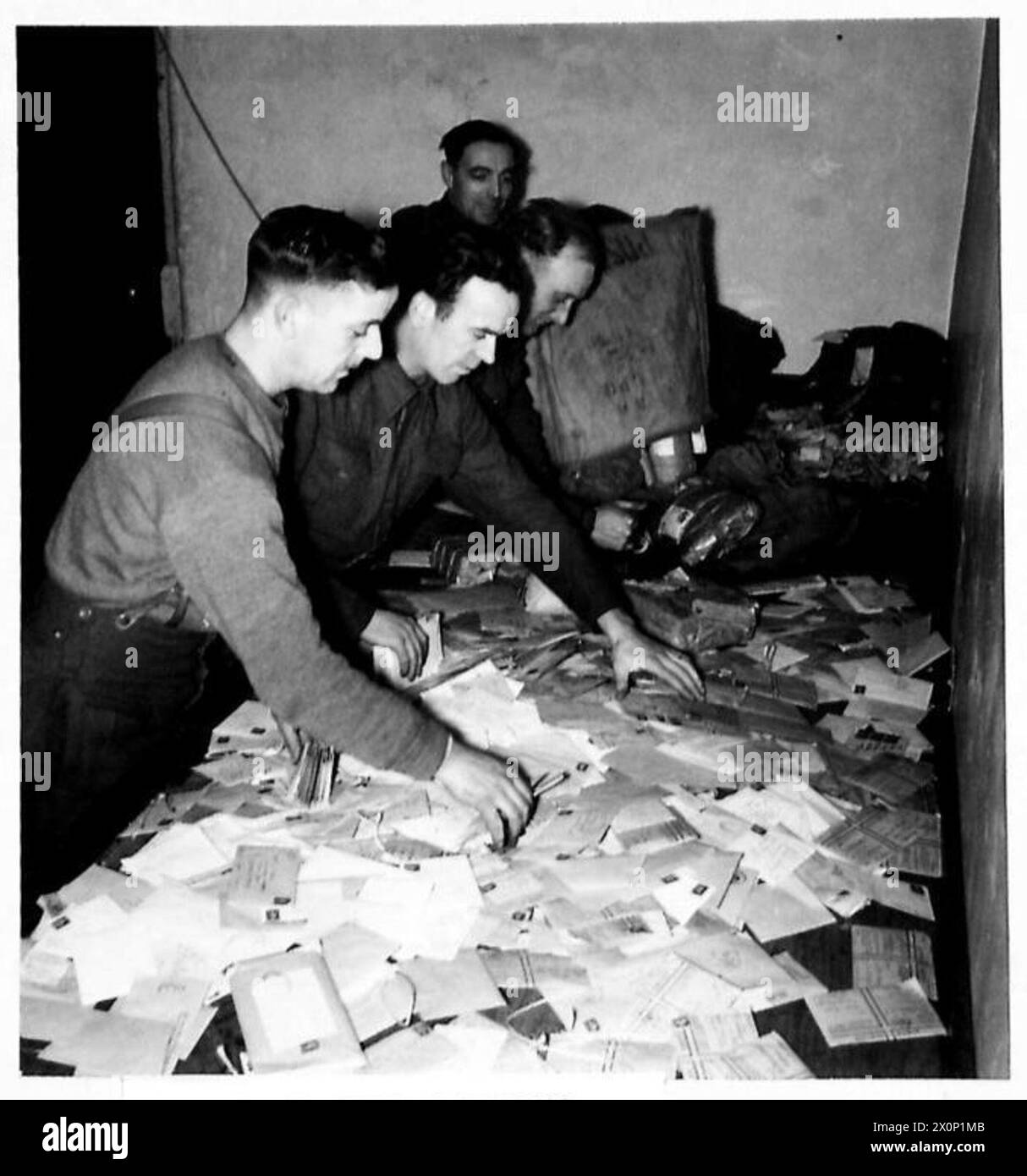 Le courrier est vidé sur le comptoir du bureau de poste de l'armée pour être trié. Les « enveloppes vertes » permettent aux soldats d'envoyer des lettres personnelles exemptes de censure régimentaire. Négatif photographique de l'armée britannique. Banque D'Images