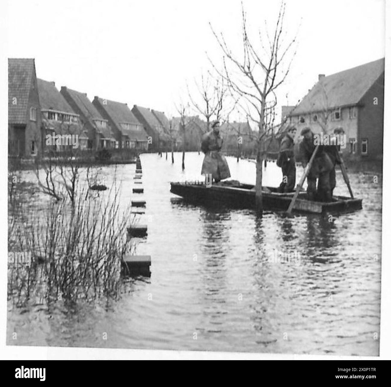 L'ÎLE INONDÉE DE WALCHEREN - bateau de sauvetage passant dans la rue inondée. Négatif photographique, Armée britannique, 21e groupe d'armées Banque D'Images