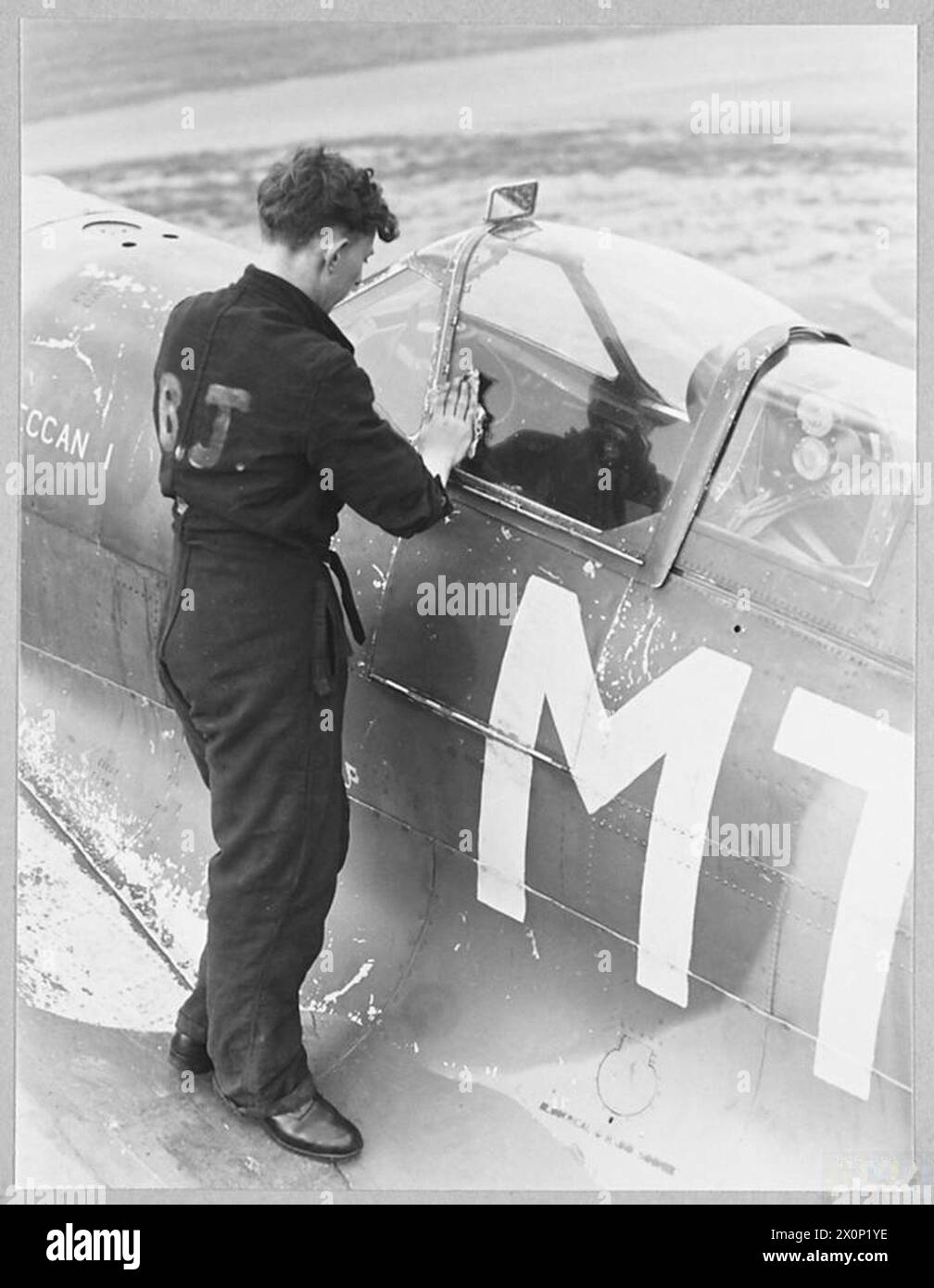 Le capot de cockpit en perspex d'un Spitfire reçoit un dernier polissage dans un poste de commandement des chasseurs de la RAF. La propreté est essentielle pour la sécurité du pilote. Négatif photographique, Royal Air Force. Banque D'Images