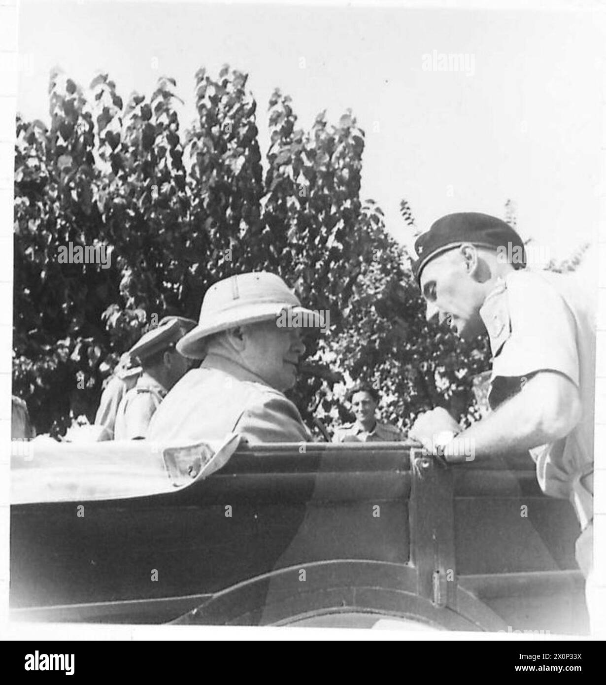 Photo négative montrant le général Władysław Anders du 2e corps polonais parlant avec le premier ministre Winston Churchill, en présence du général Harold Alexander, lors de la visite de Churchill au QG de la 8e armée britannique en Italie, 1944, illustrant le leadership militaire et la coordination alliée. Banque D'Images