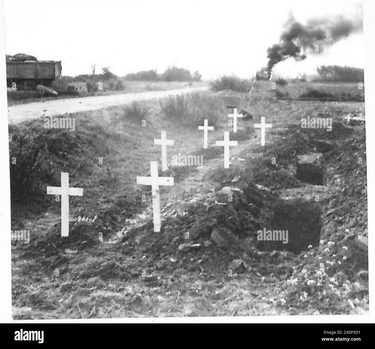 Quelques tombes de soldats britanniques sont visibles avec un camion flamboyant en arrière-plan en Italie. Négatif photographique, armée britannique. Banque D'Images